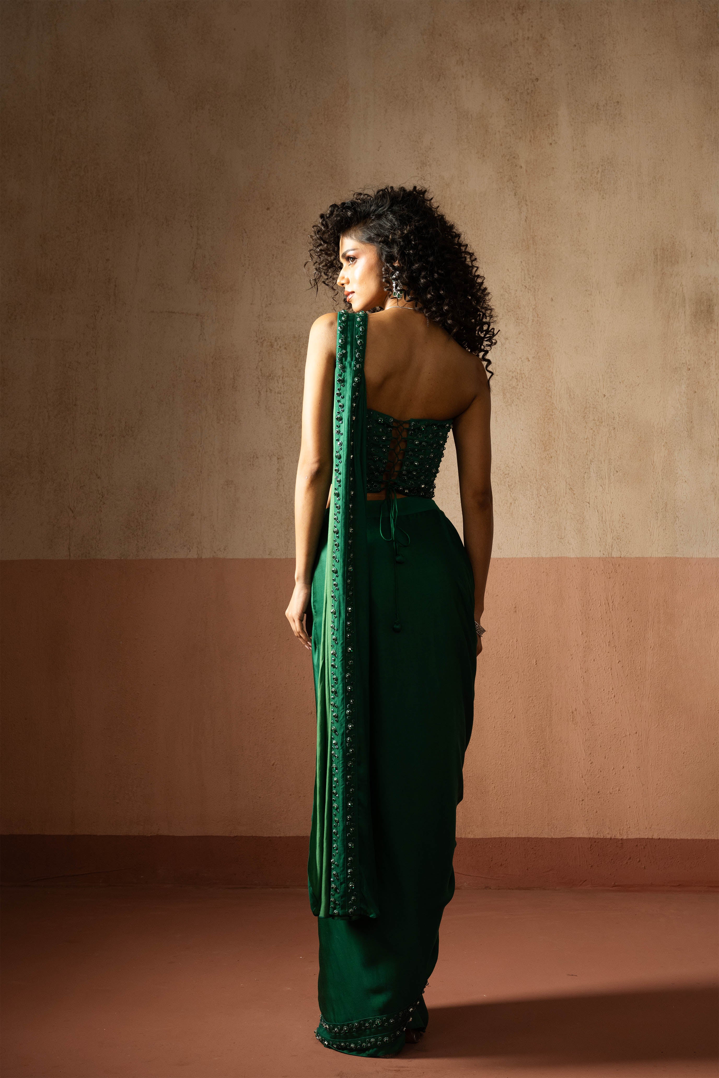 Predraped, emerald green hand embroidered satin saree with corset blouse