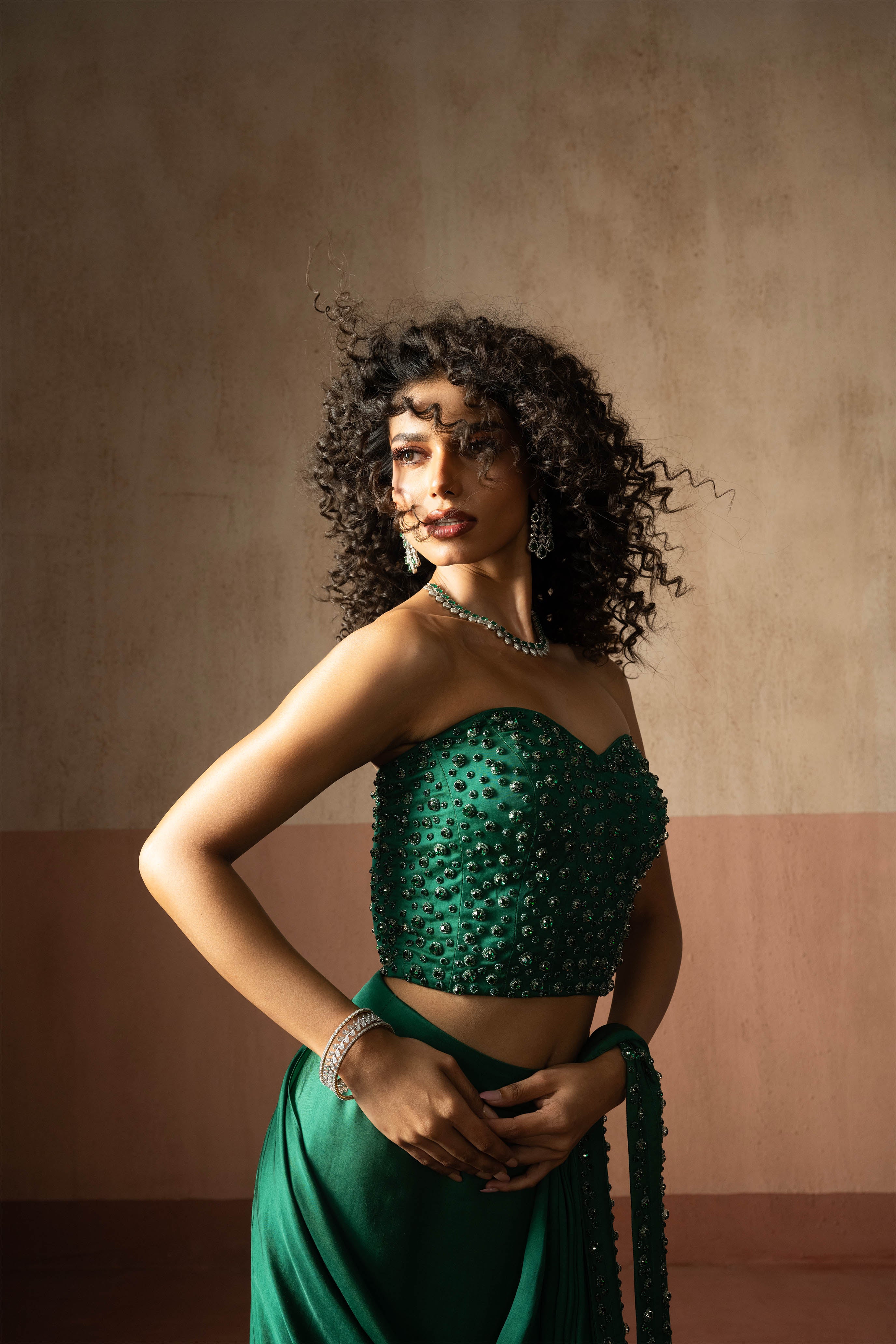 Predraped, emerald green hand embroidered satin saree with corset blouse
