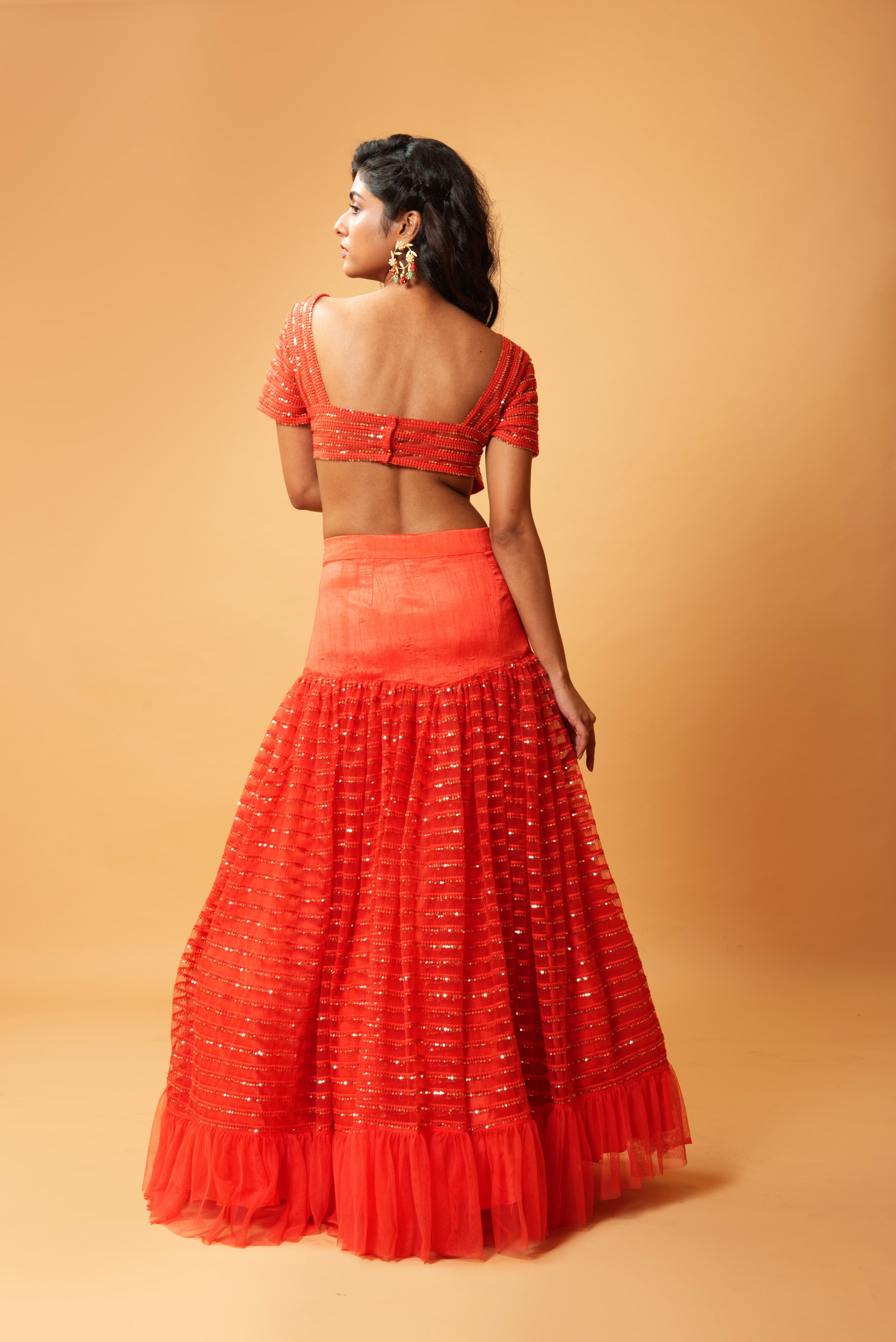 Red ruffle lehenga with hand-embroidered blouse and organza dupatta.
