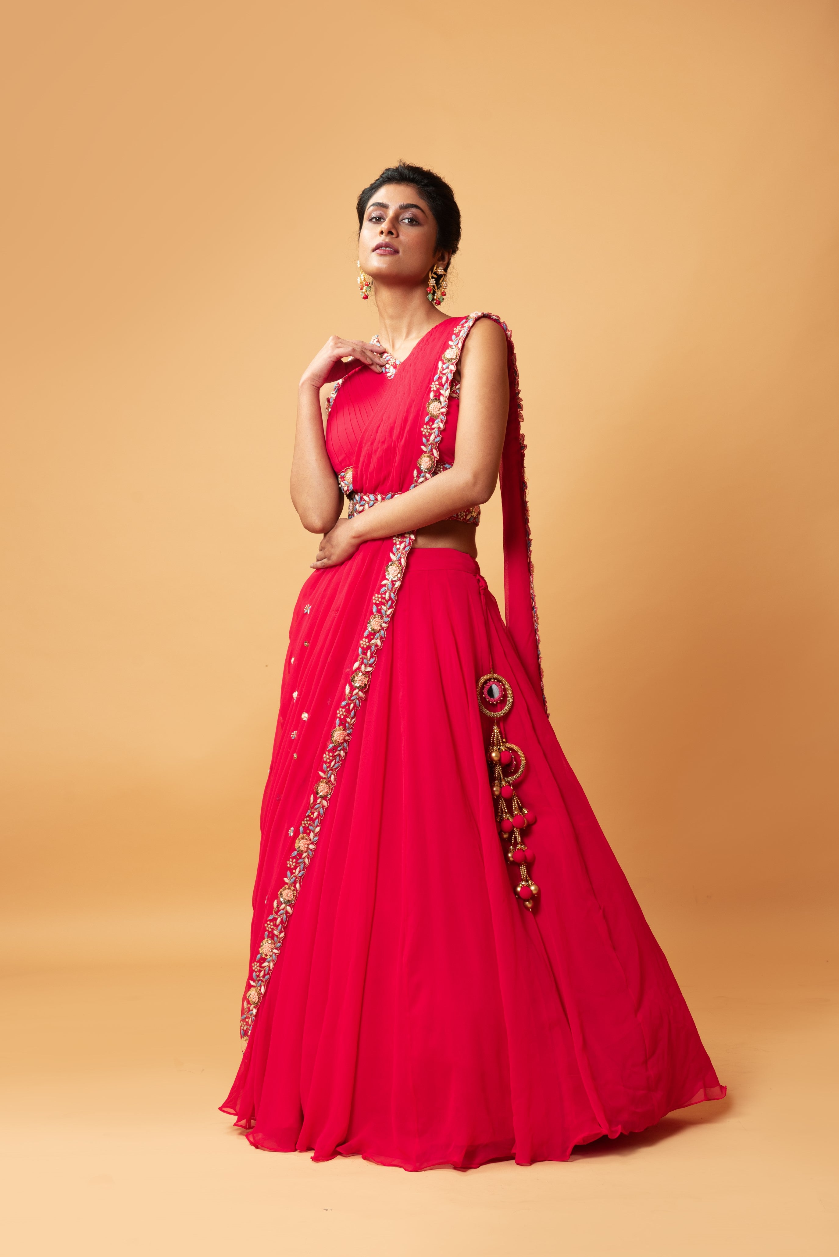 Fuschia pink draped lehenga with hand-embroidered waist belt.