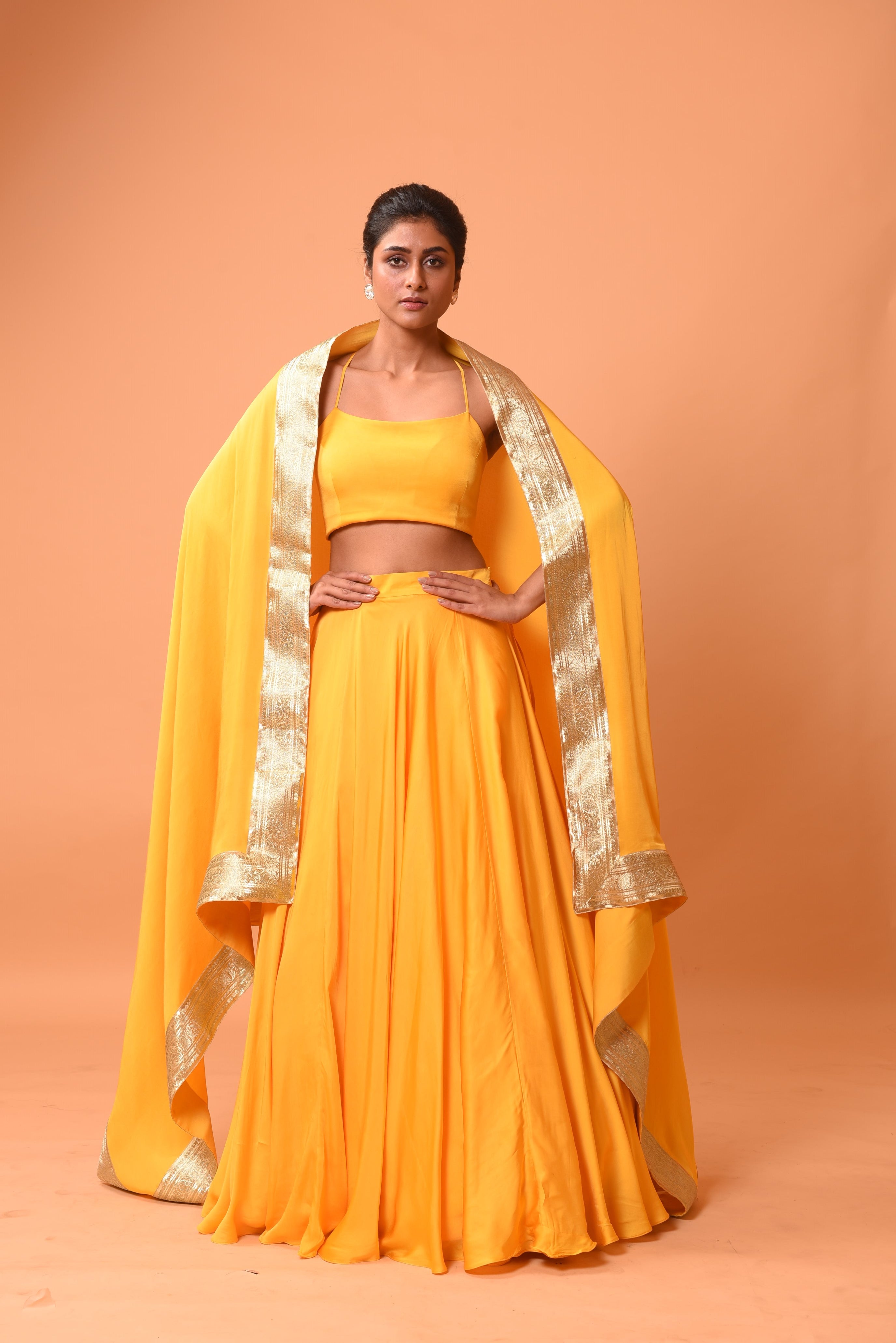 Bright yellow sleeveless lehenga with golden zari-bordered dupatta.
