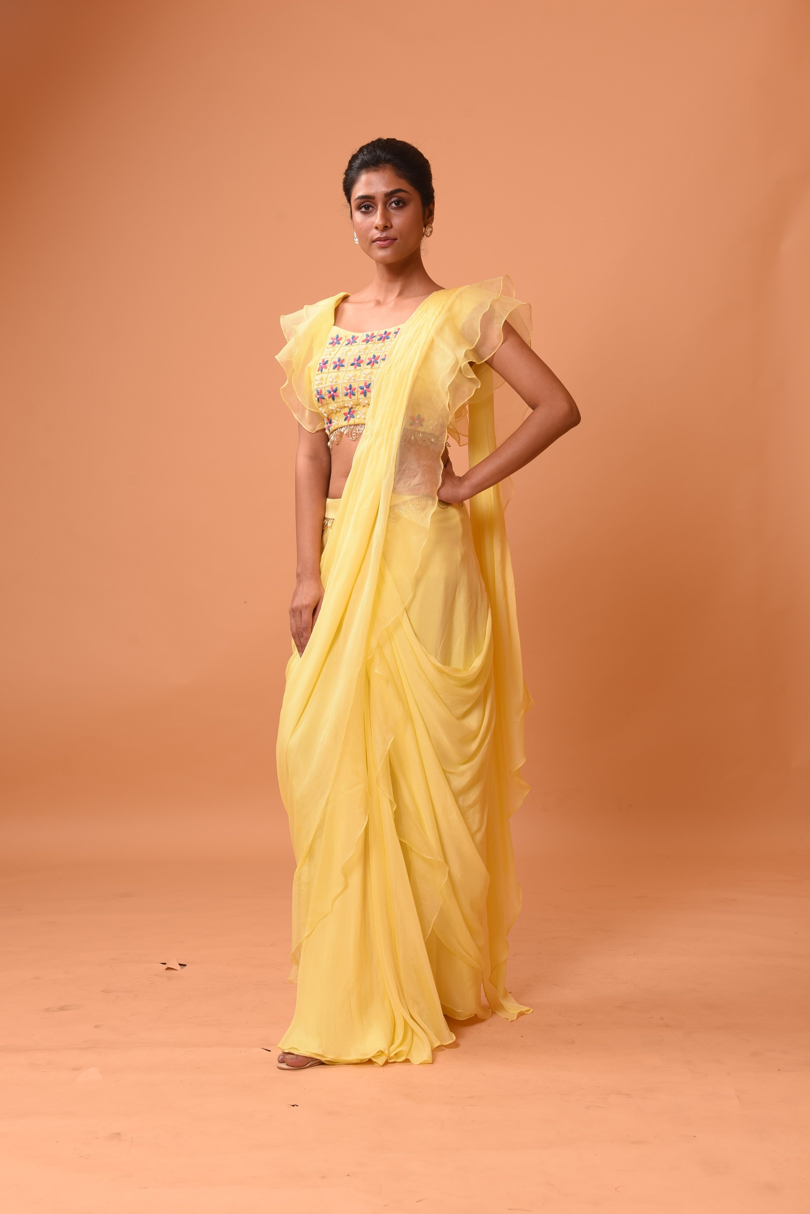 Yellow ruffle saree with lace work and embroidered blouse featuring intricate handwork.