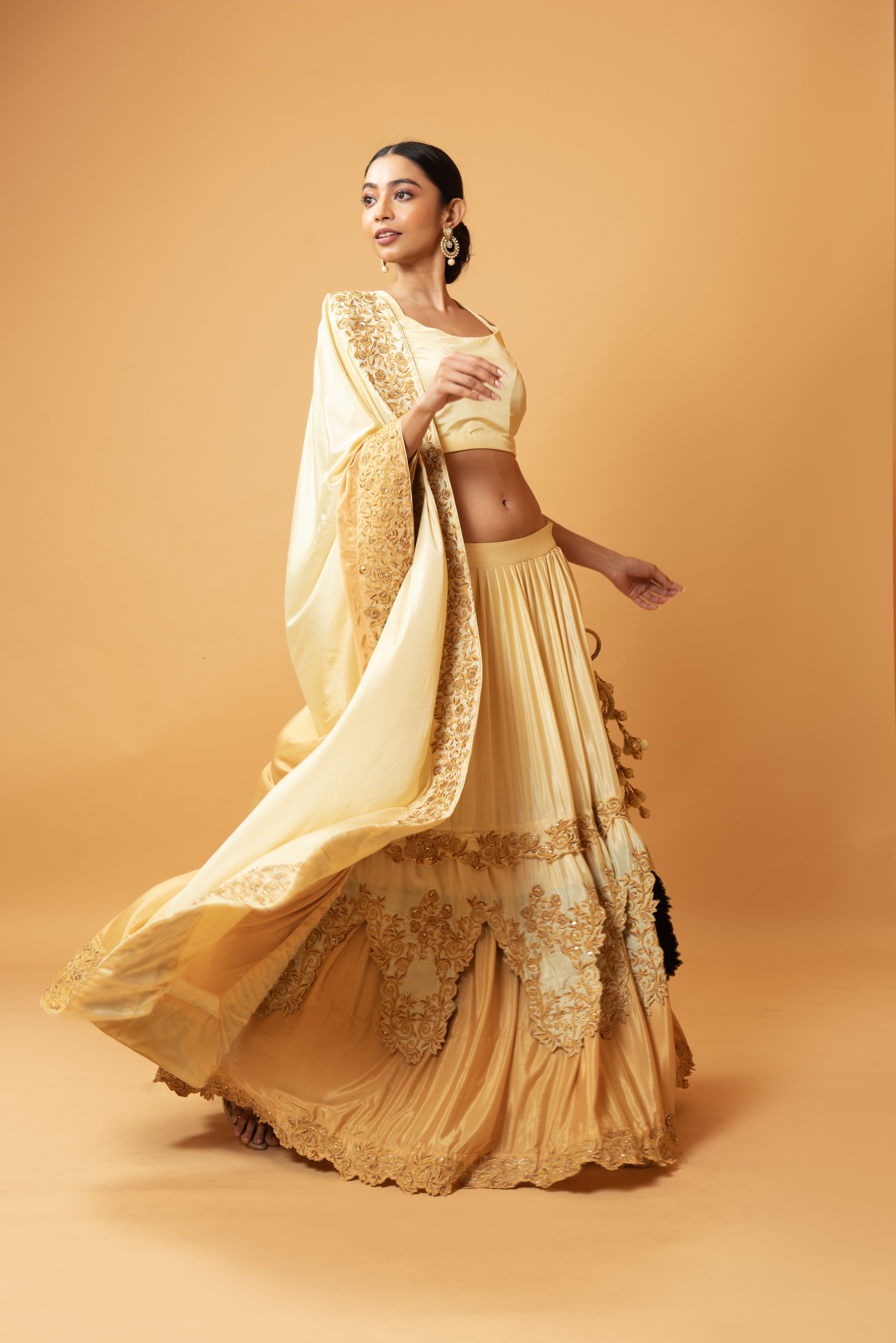 Golden ombre lehenga with floral embroidery and layered design.
