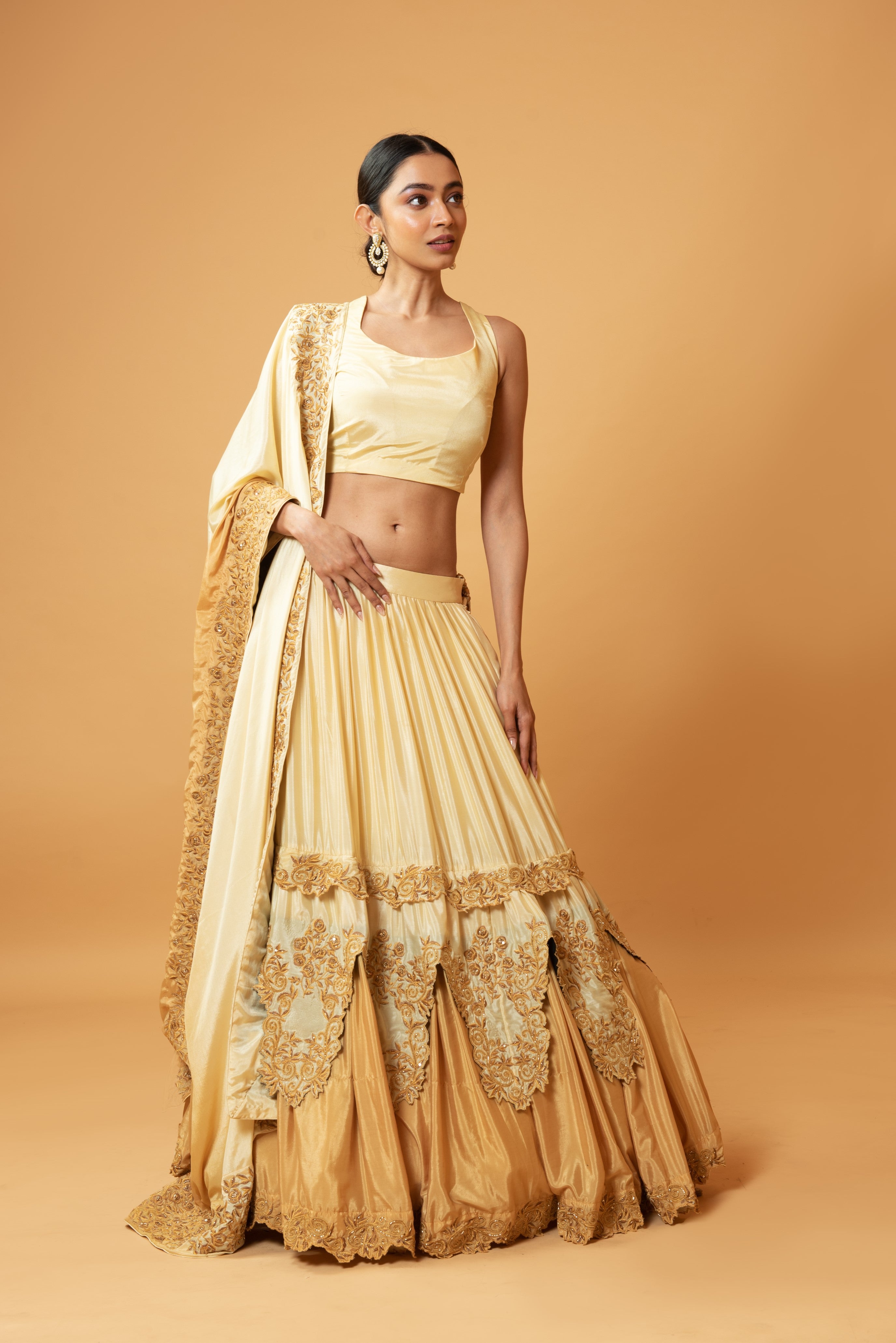 Golden ombre lehenga with floral embroidery and layered design.