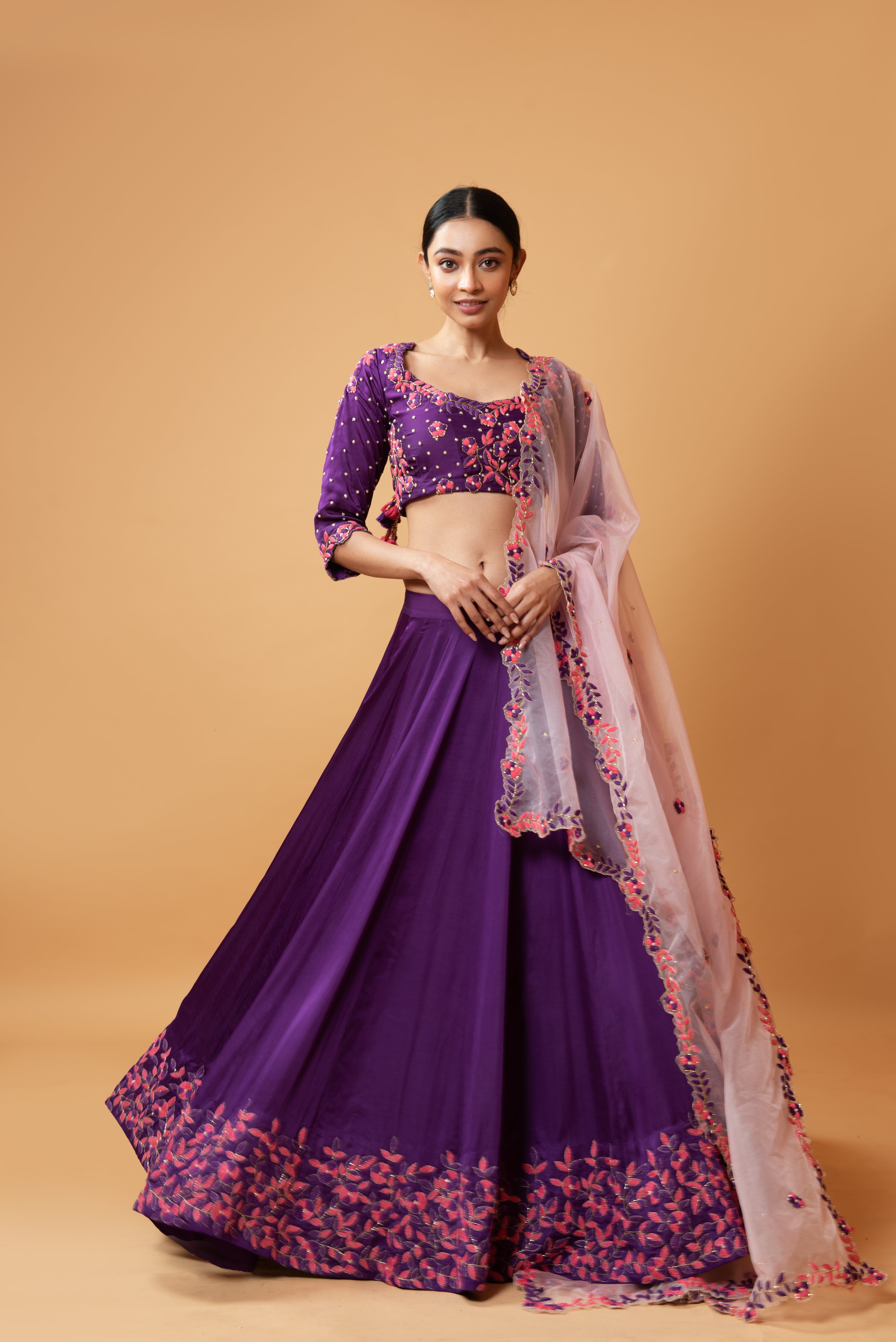 Violet lehenga with handwork paired with a contrasting pink dupatta.