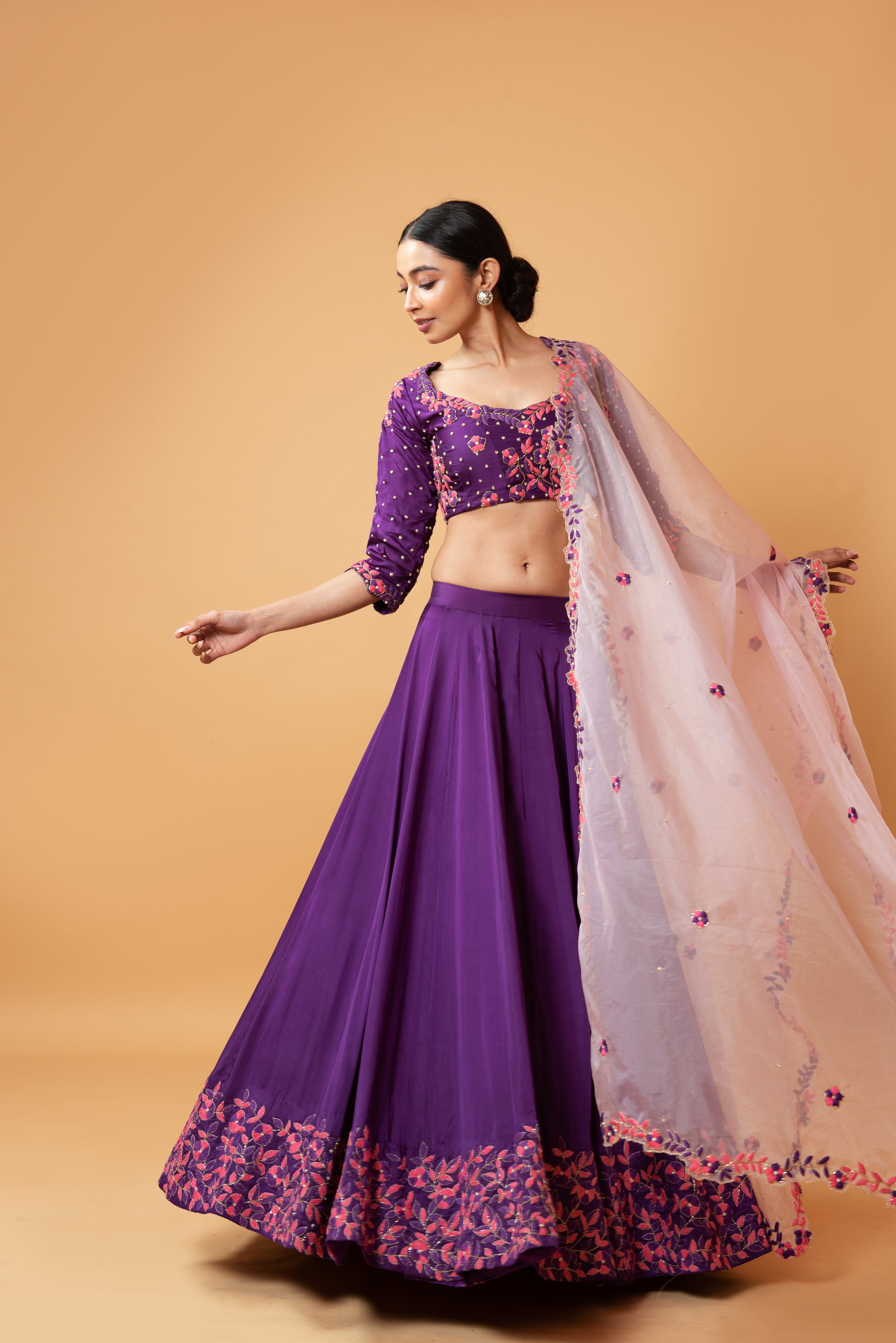 Violet lehenga with handwork paired with a contrasting pink dupatta.