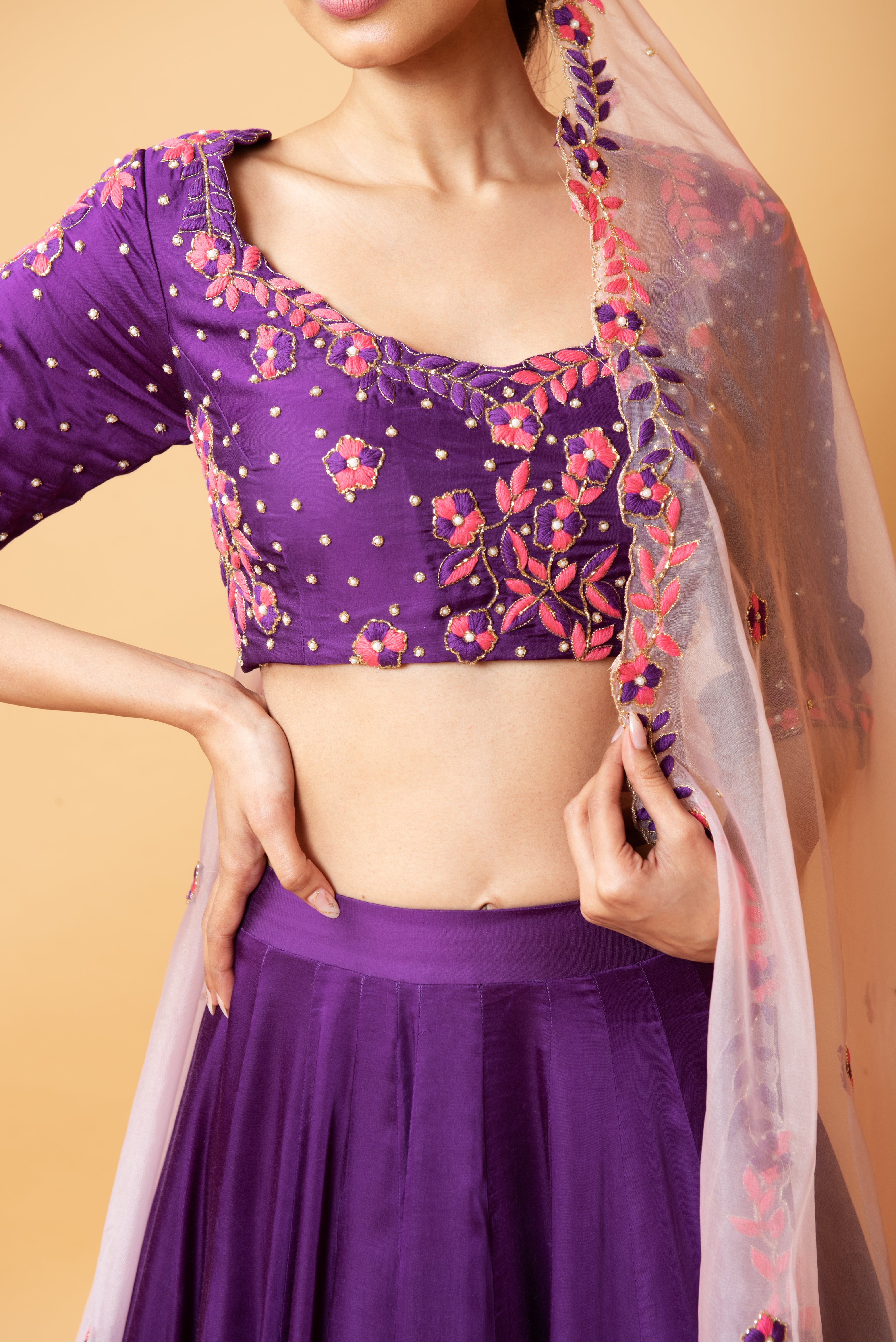 Violet lehenga with handwork paired with a contrasting pink dupatta.