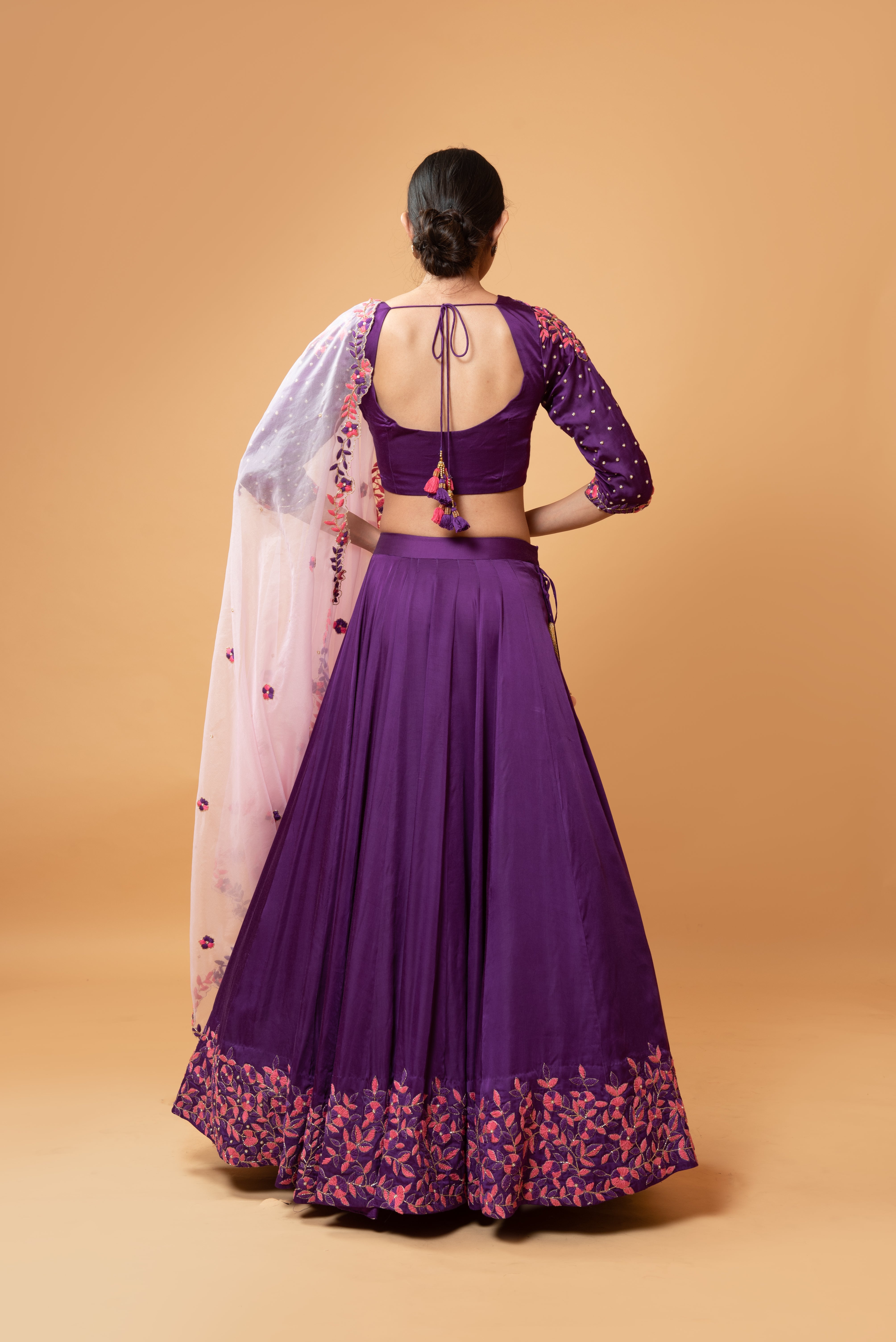 Violet lehenga with handwork paired with a contrasting pink dupatta.