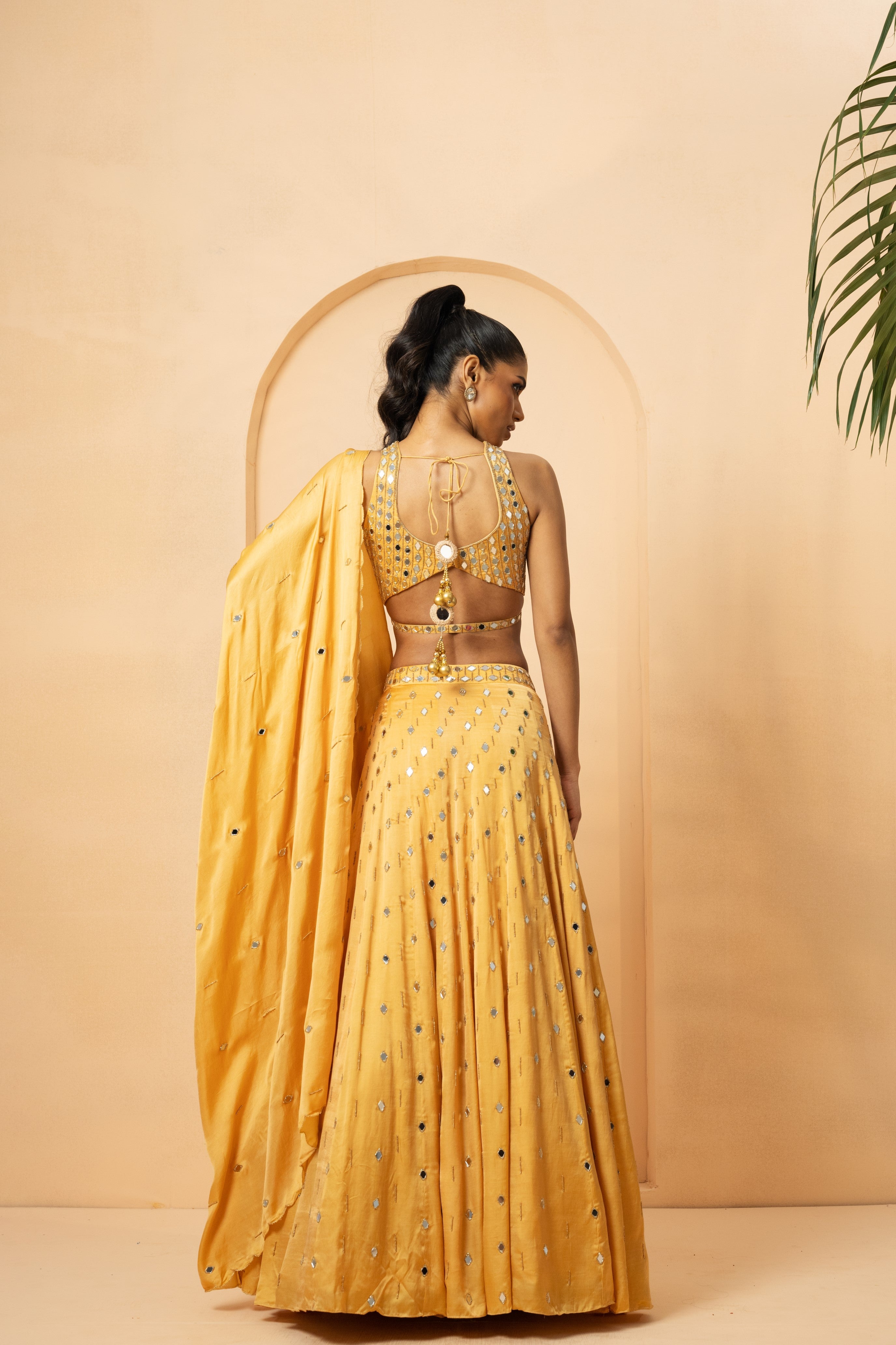 Golden lehenga with mirror and pearl embellishments on blouse and dupatta.