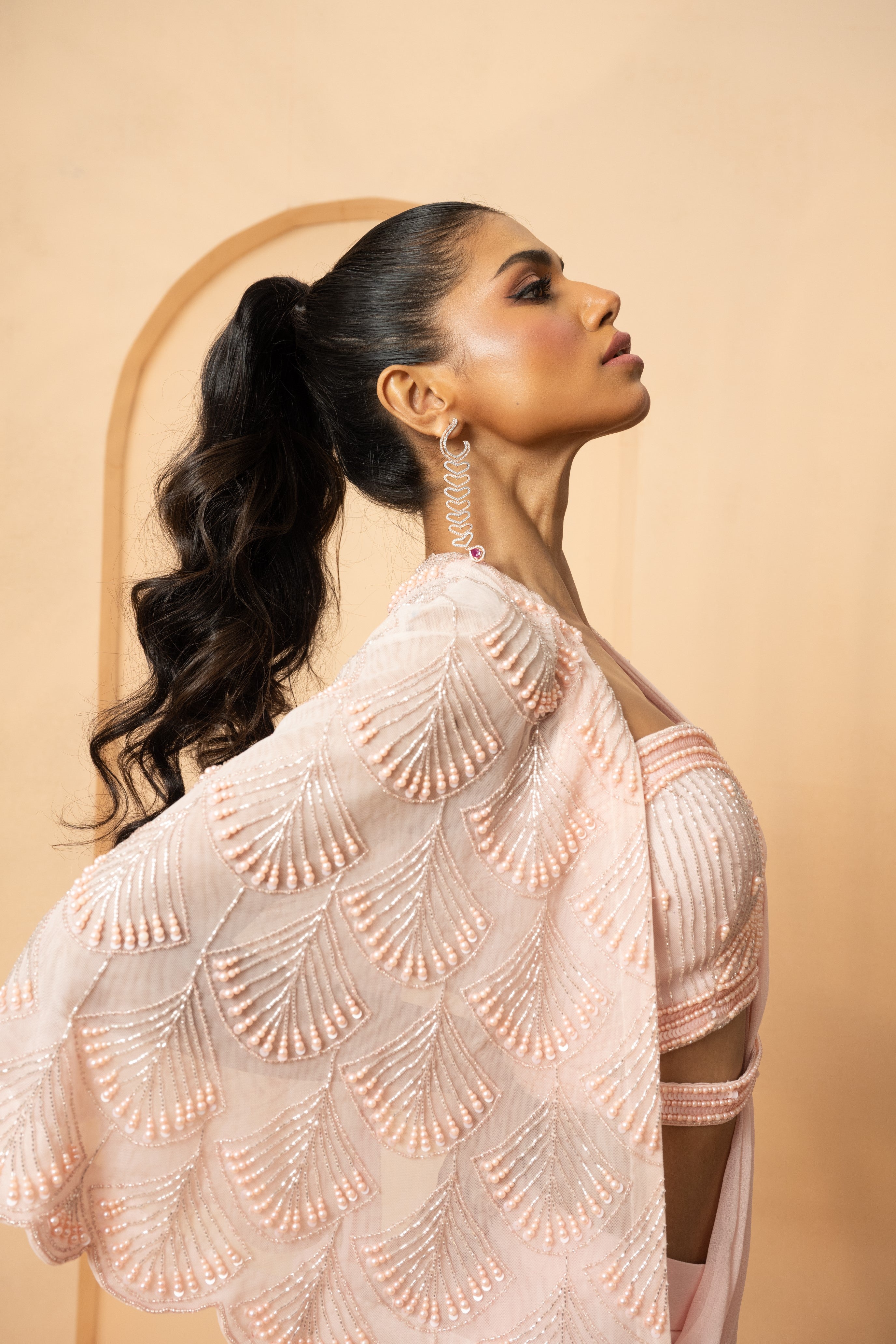 Baby pink pre-stitched drape saree with a pearl-beaded embroidered cape.