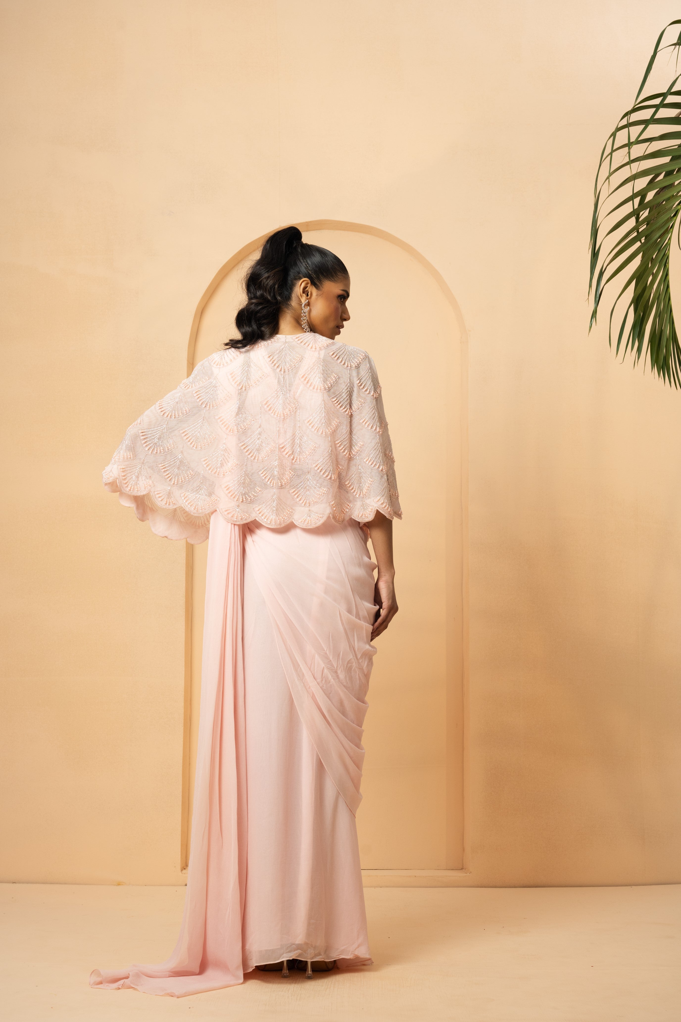 Baby pink pre-stitched drape saree with a pearl-beaded embroidered cape.