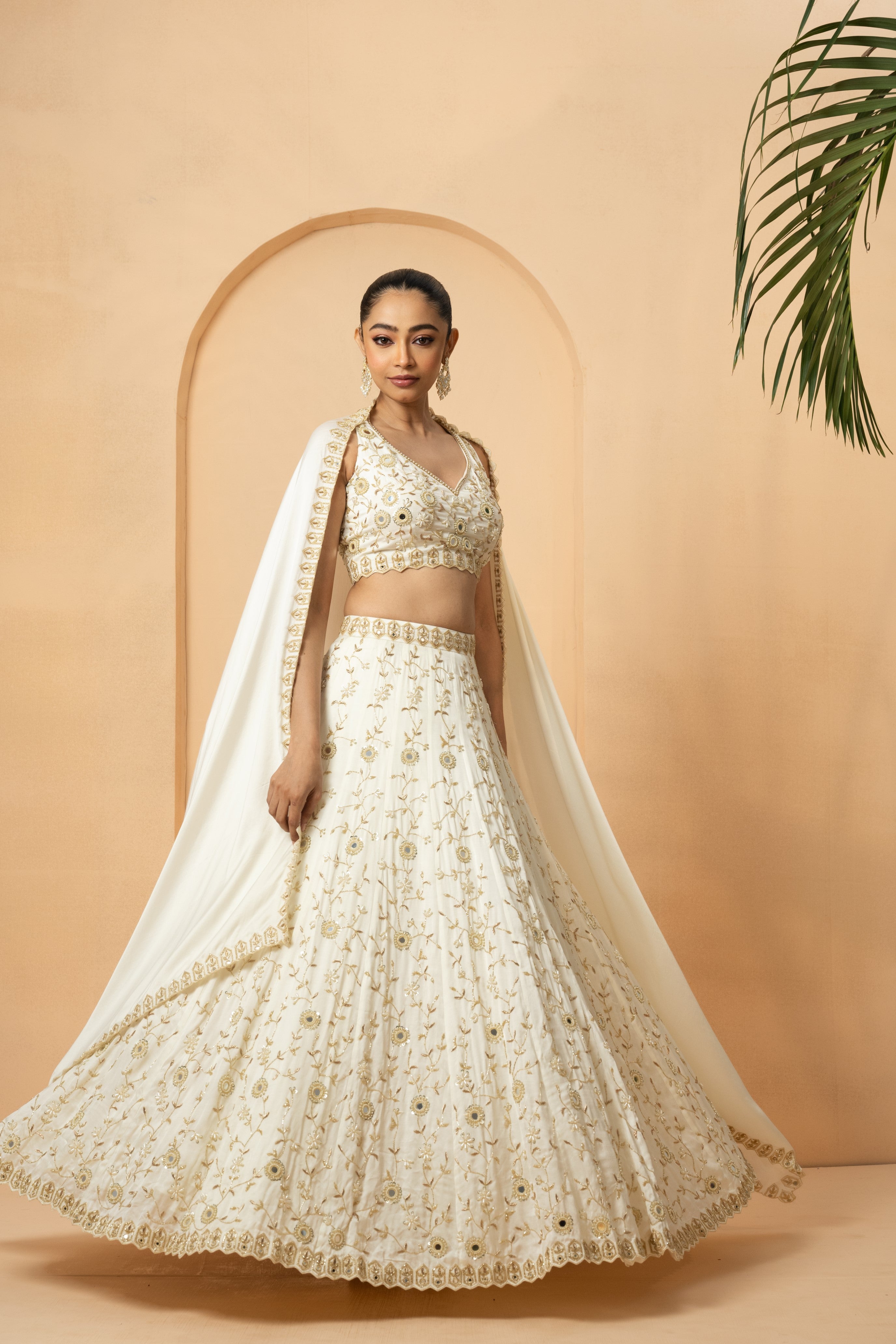 Ivory lehenga with mirror and pearl bead embellishments, paired with a matching dupatta.