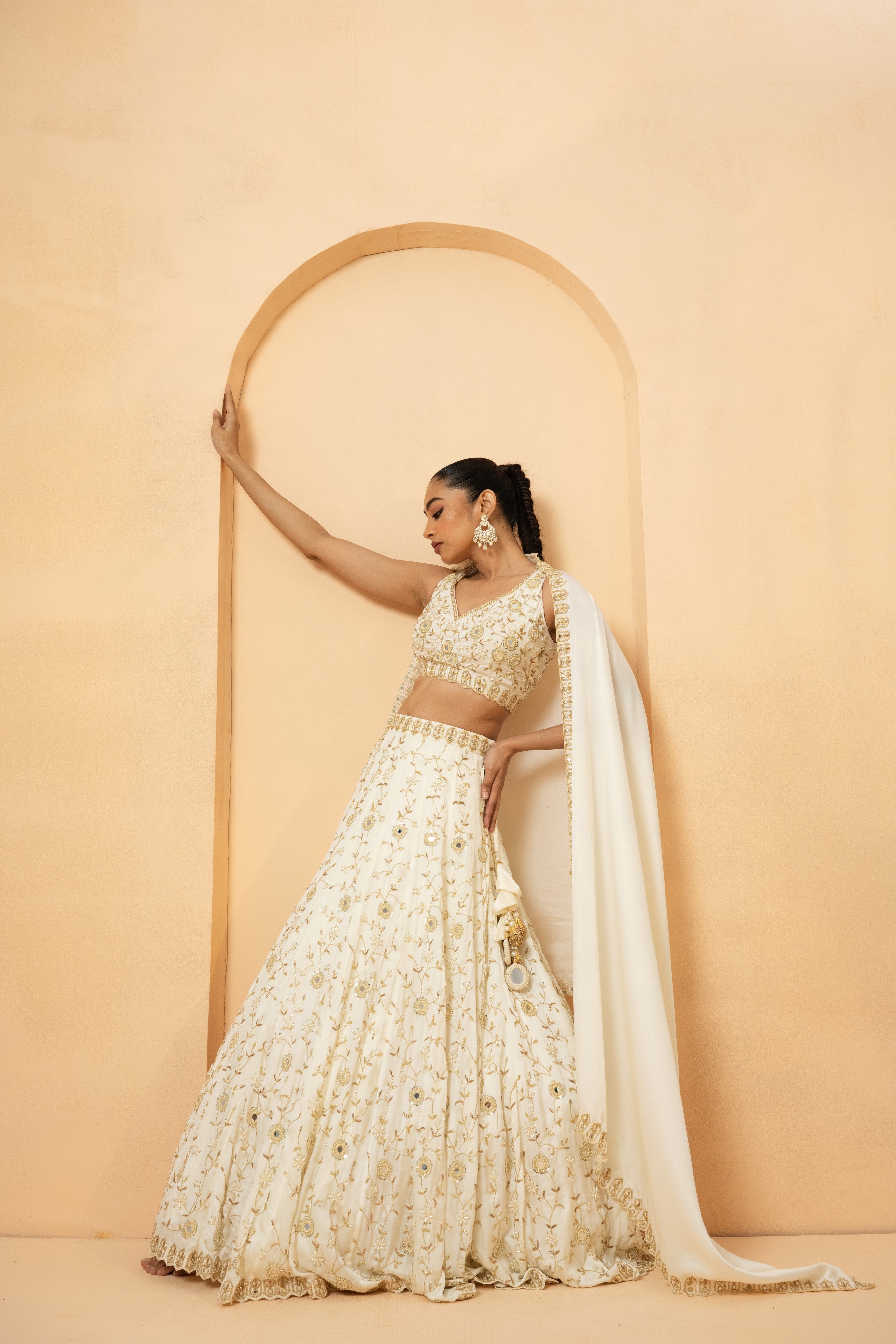 Ivory lehenga with mirror and pearl bead embellishments, paired with a matching dupatta.