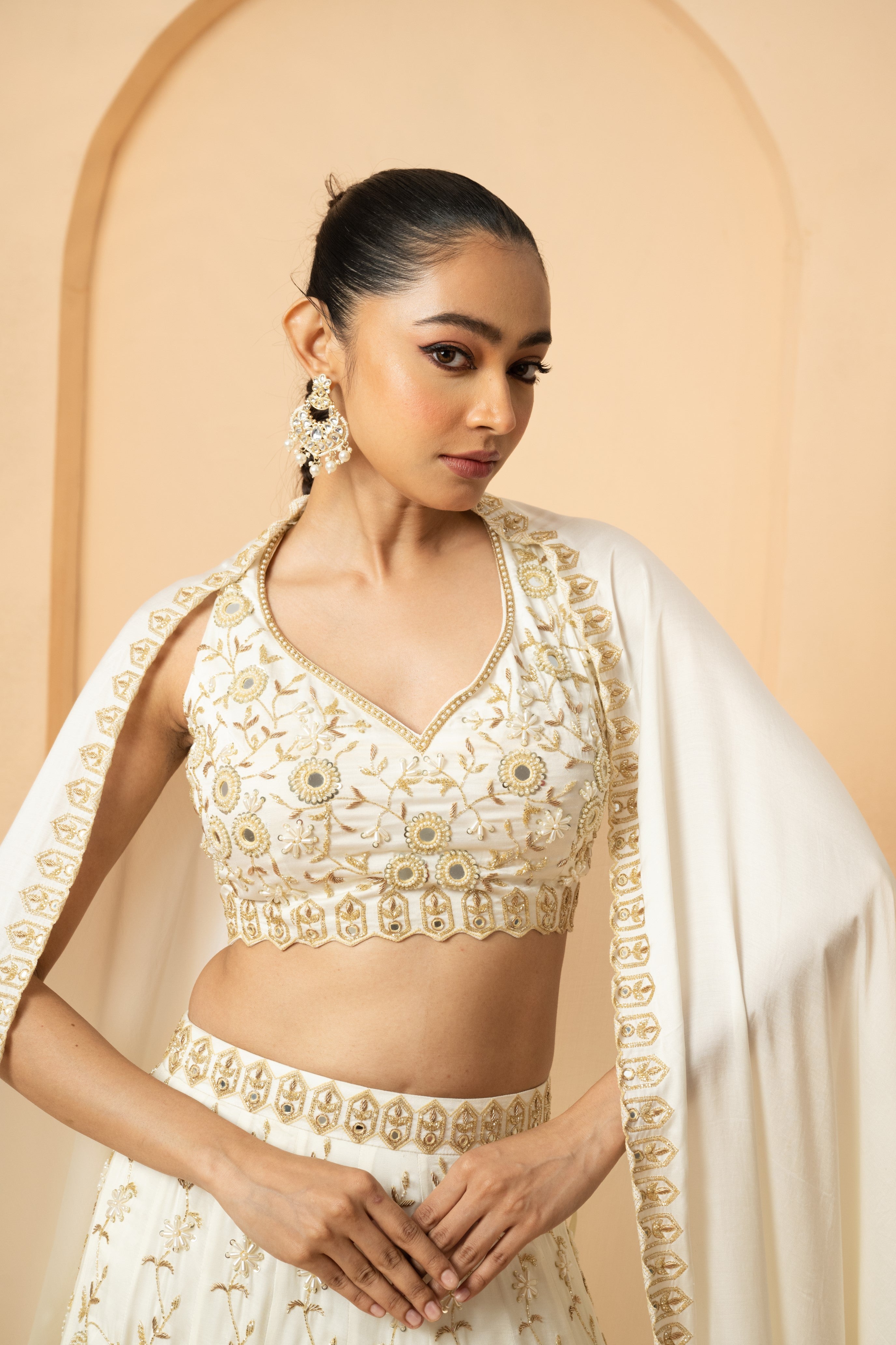 Ivory lehenga with mirror and pearl bead embellishments, paired with a matching dupatta.