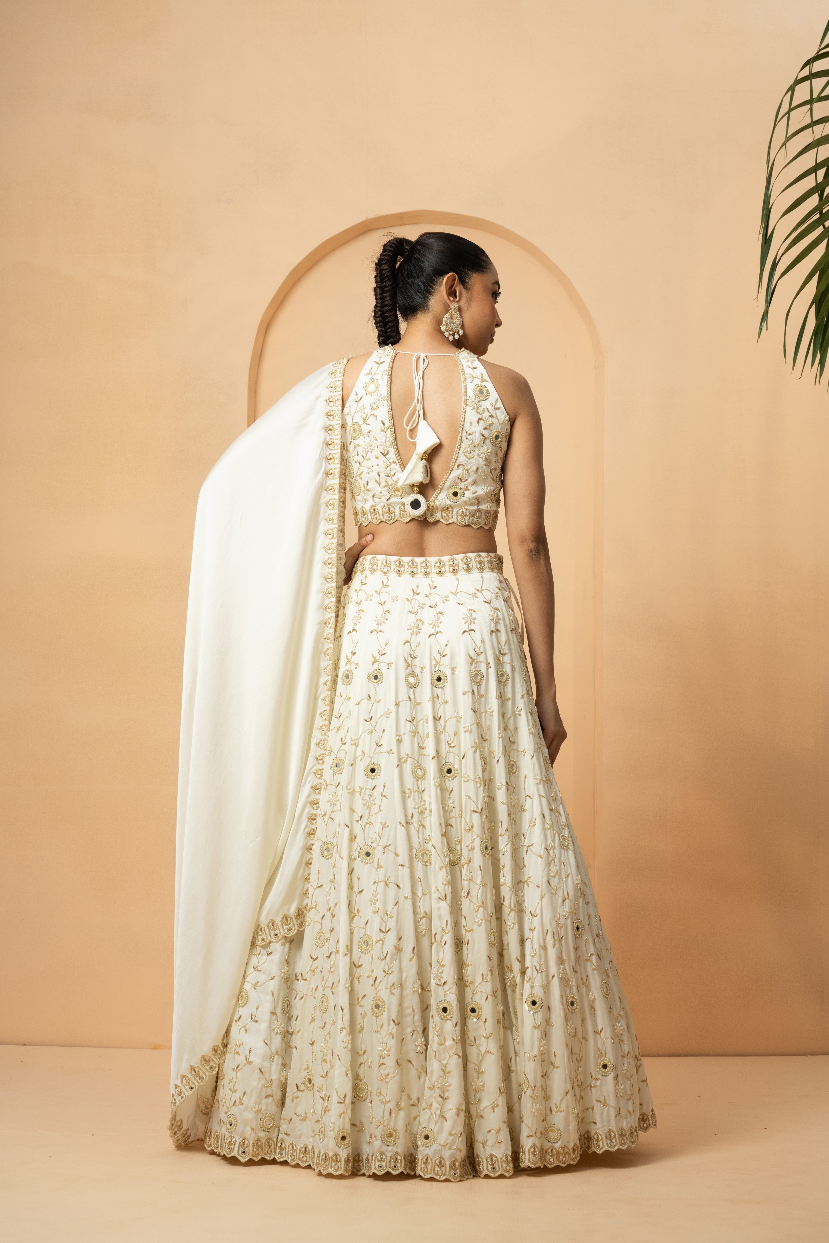 Ivory lehenga with mirror and pearl bead embellishments, paired with a matching dupatta.