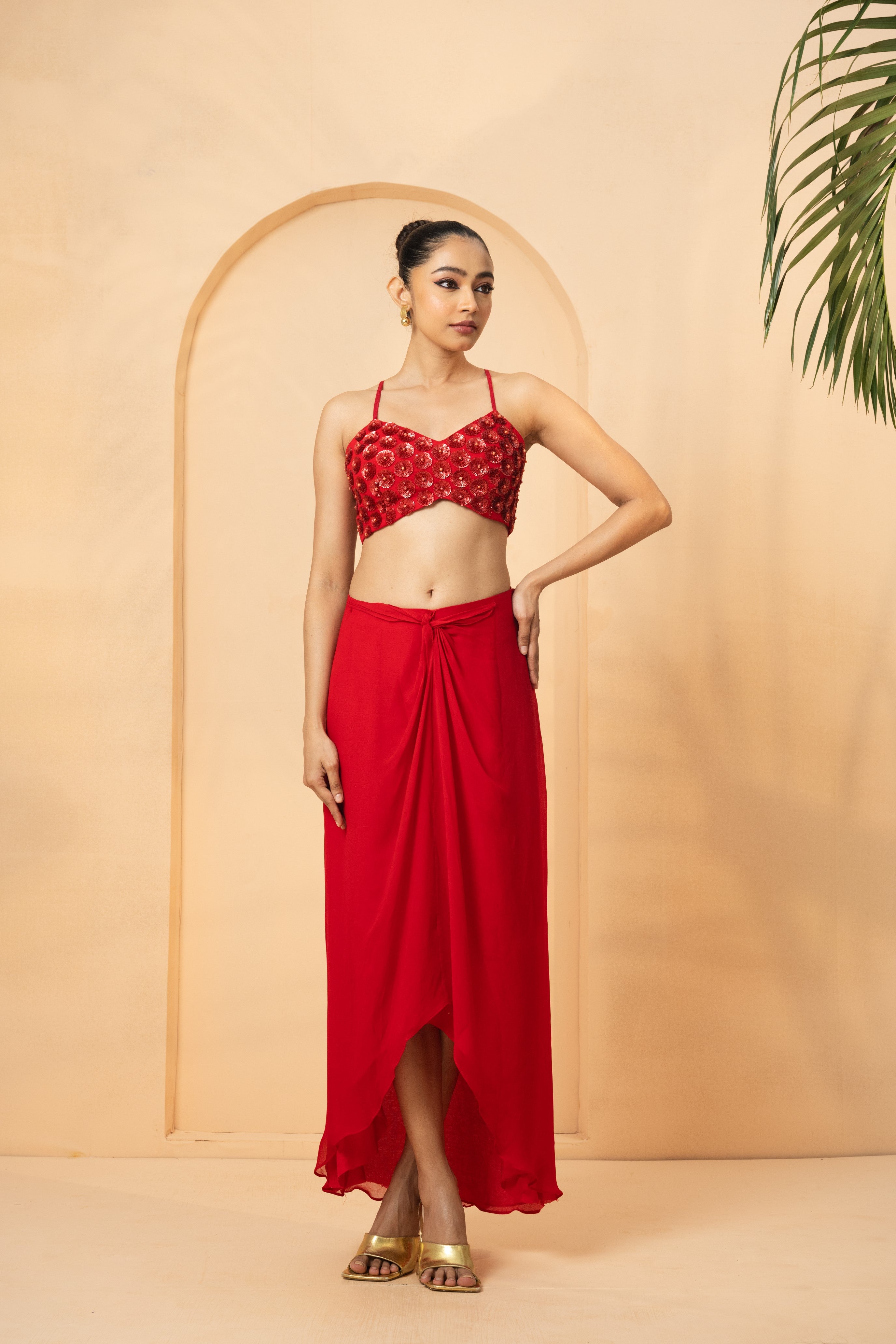 Red co-ord set with hand-embroidered blouse, cape, and dhoti skirt.