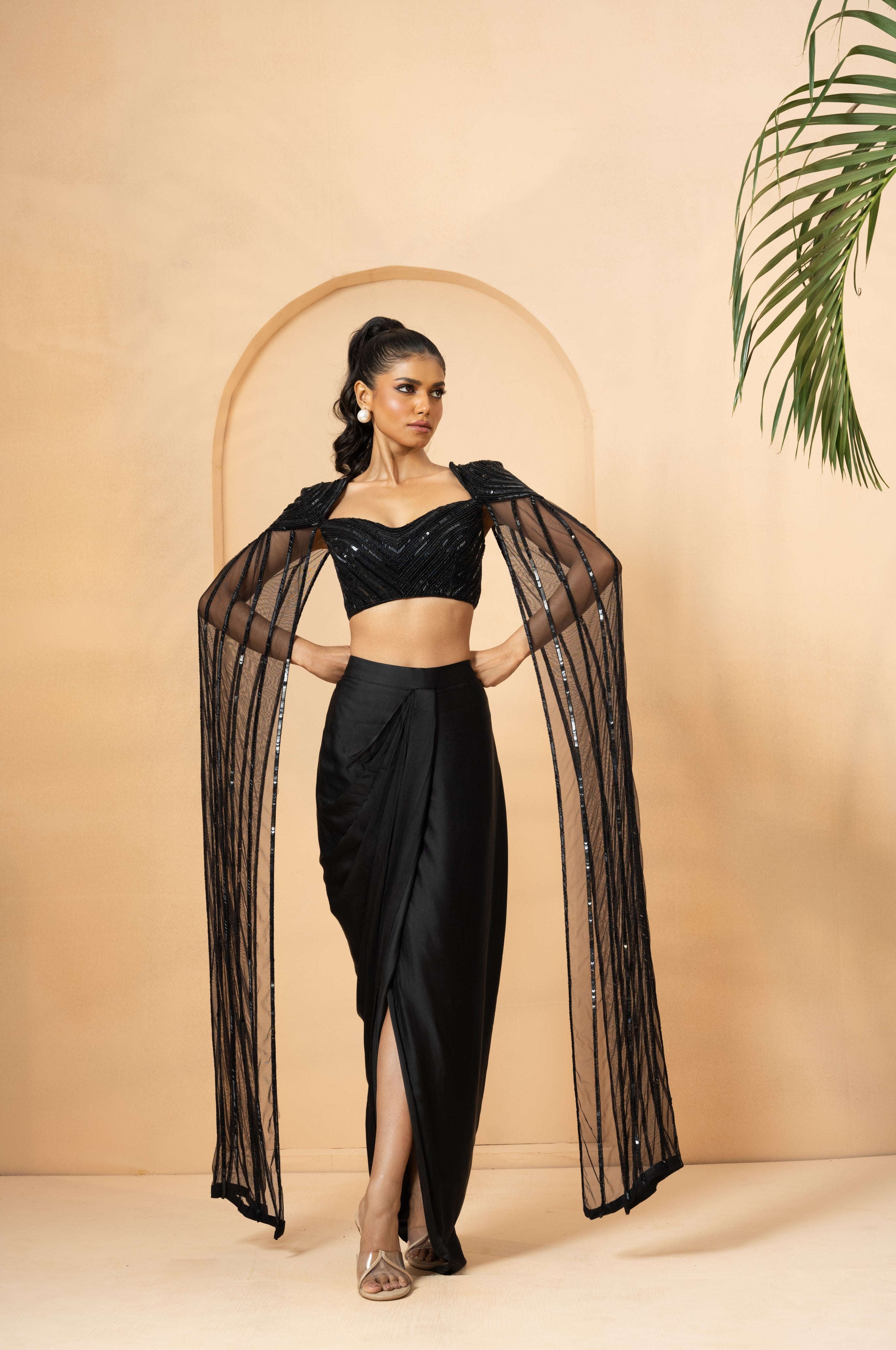 Black dhoti co-ord set with hand-embroidered blouse and attached cape.