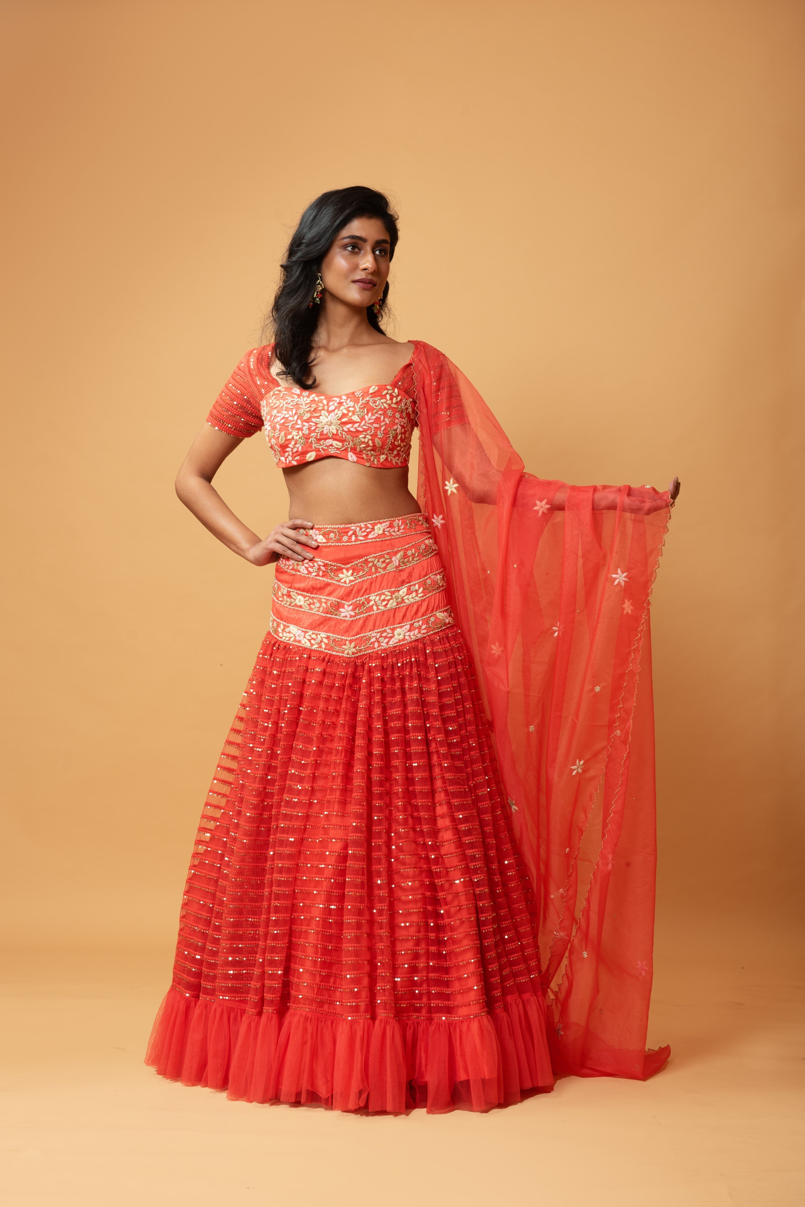Red ruffle lehenga with hand-embroidered blouse and organza dupatta.