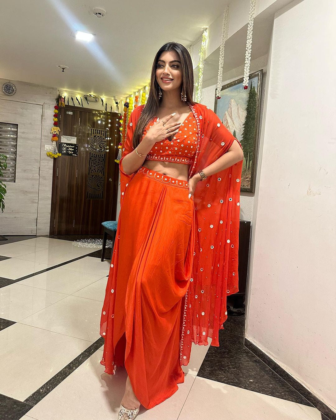 Tangerine orange dhoti set with a mirror-work blouse, dhoti, and georgette cape, worn by Akansha Puri.