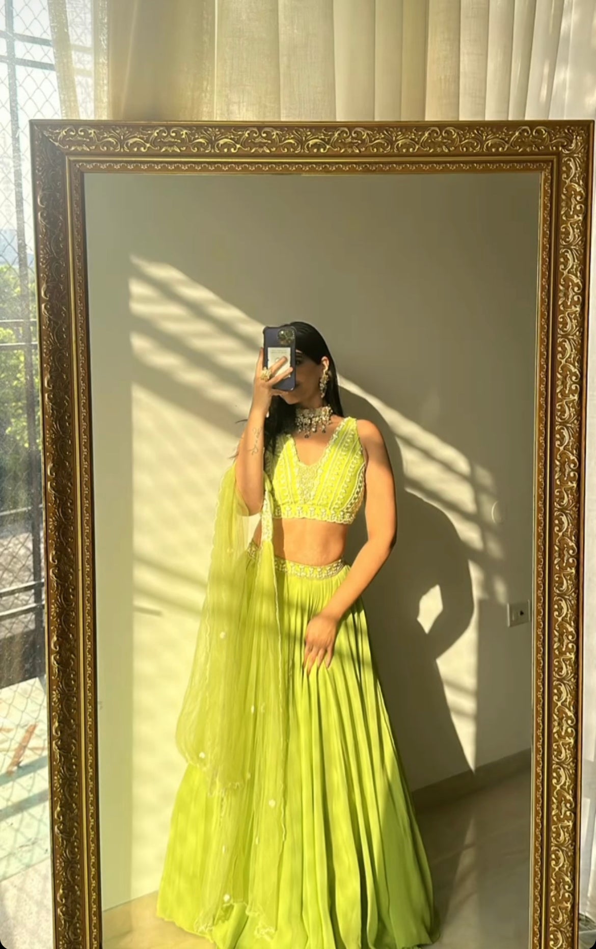 Lime green lehenga with embroidered blouse, belt, and choker dupatta.