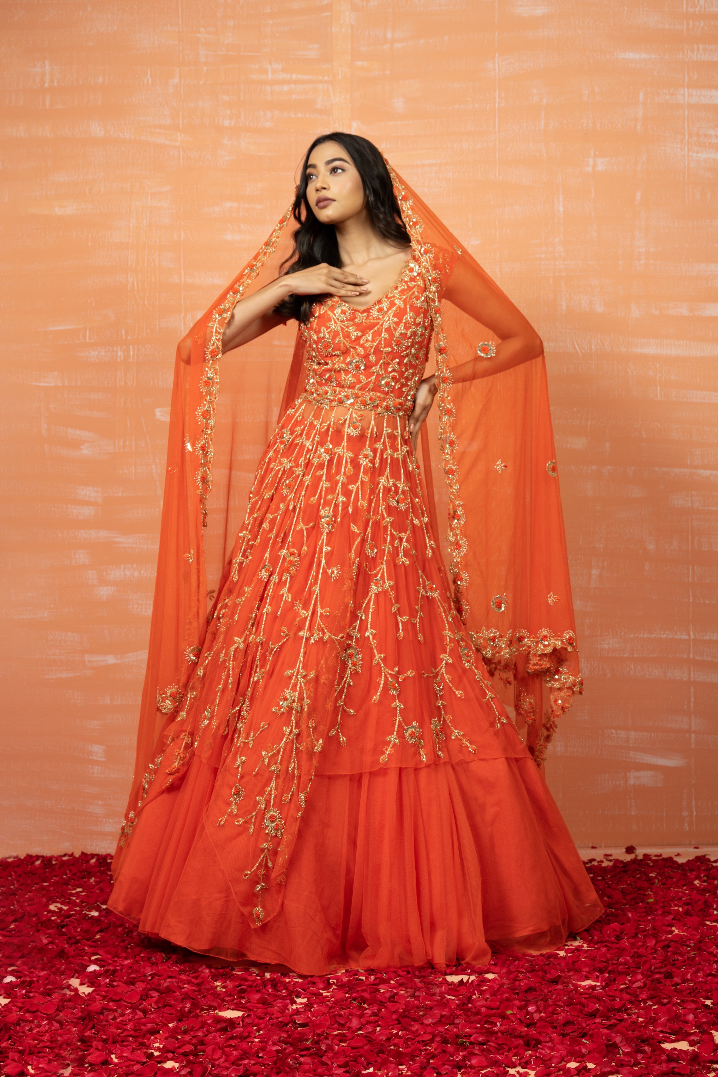 Orange soft net lehenga set with intricate zardosi embroidery, dupatta, and waist belt.