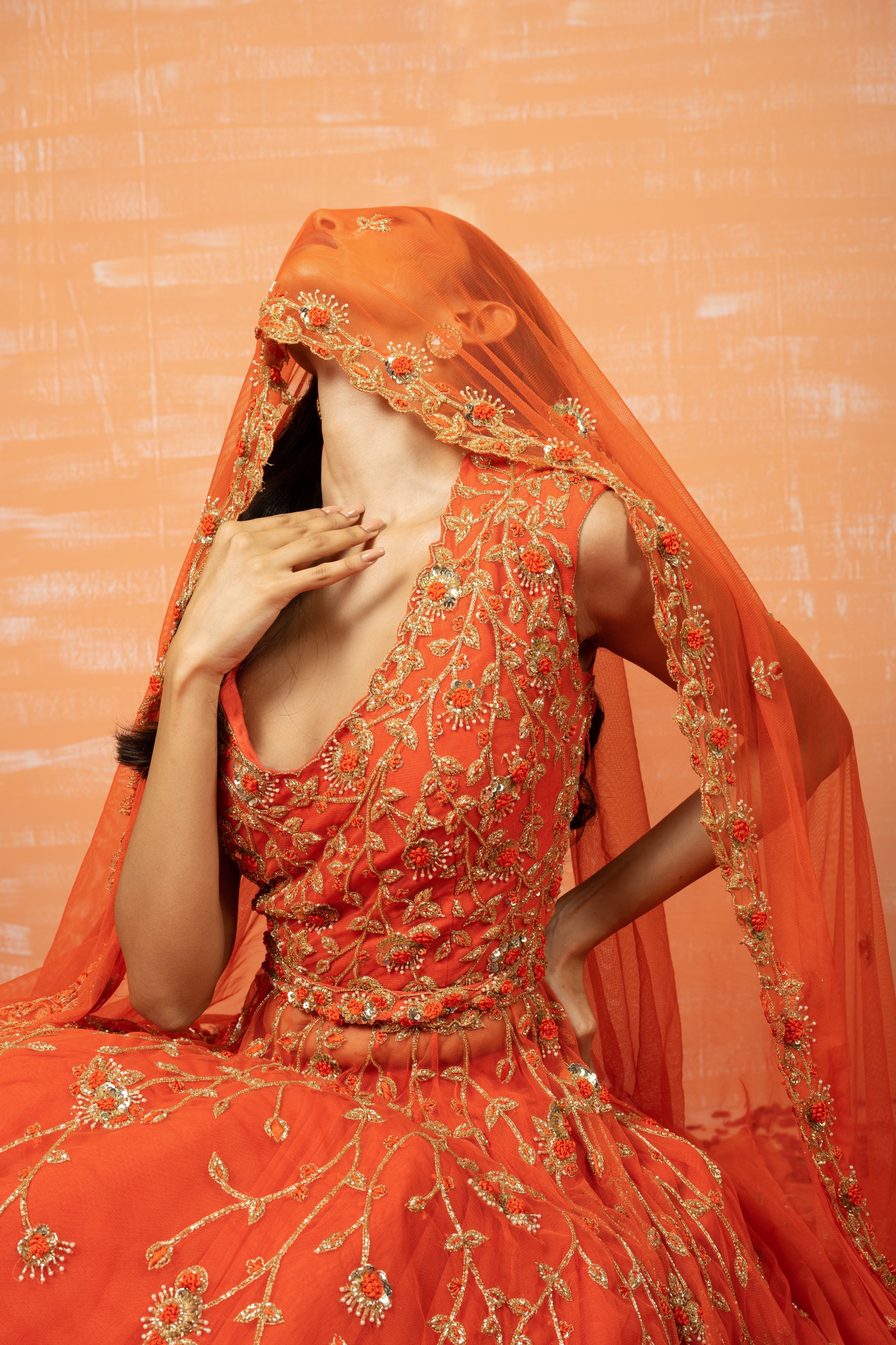 Orange soft net lehenga set with intricate zardosi embroidery, dupatta, and waist belt.