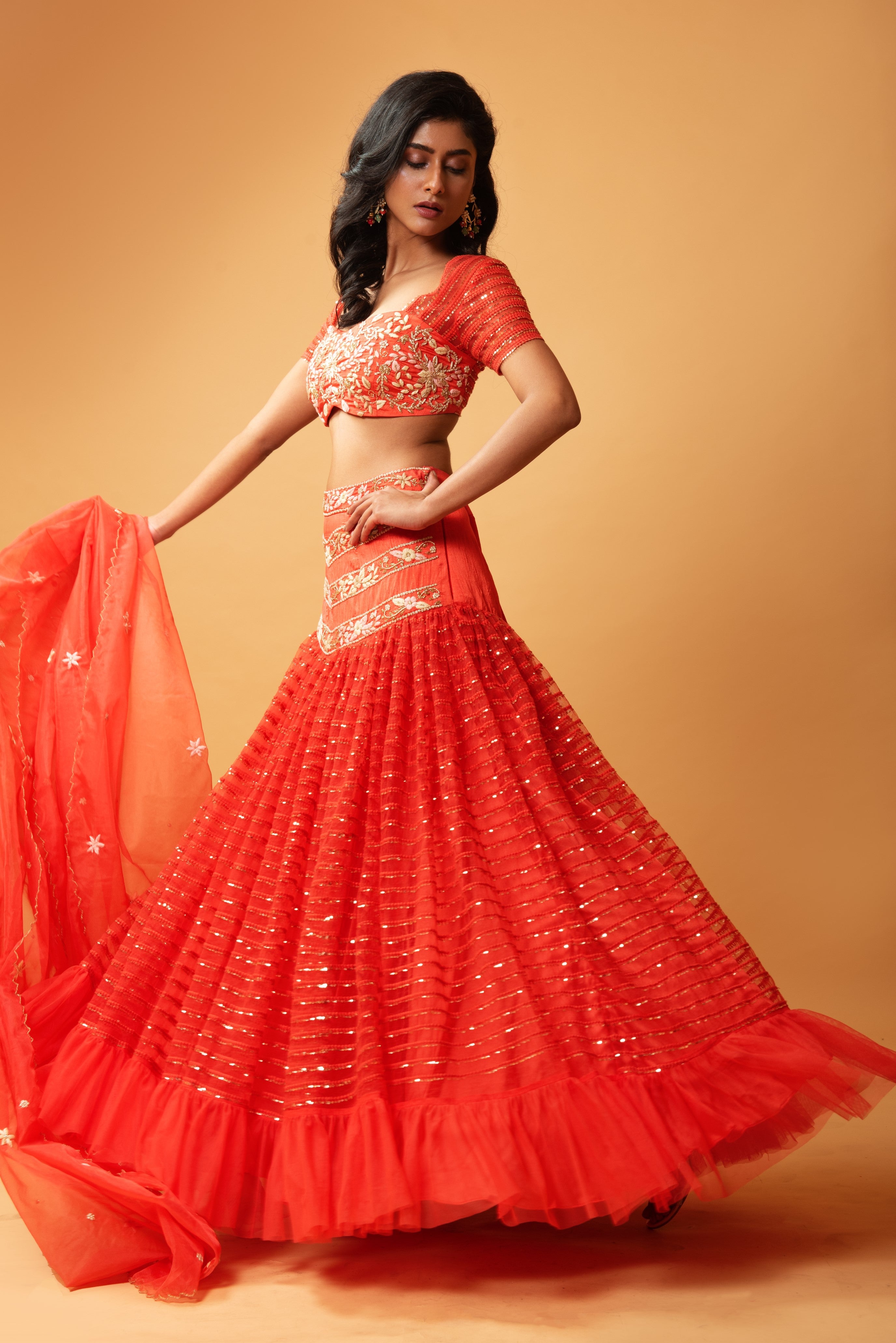 Red ruffle lehenga with hand-embroidered blouse and organza dupatta.