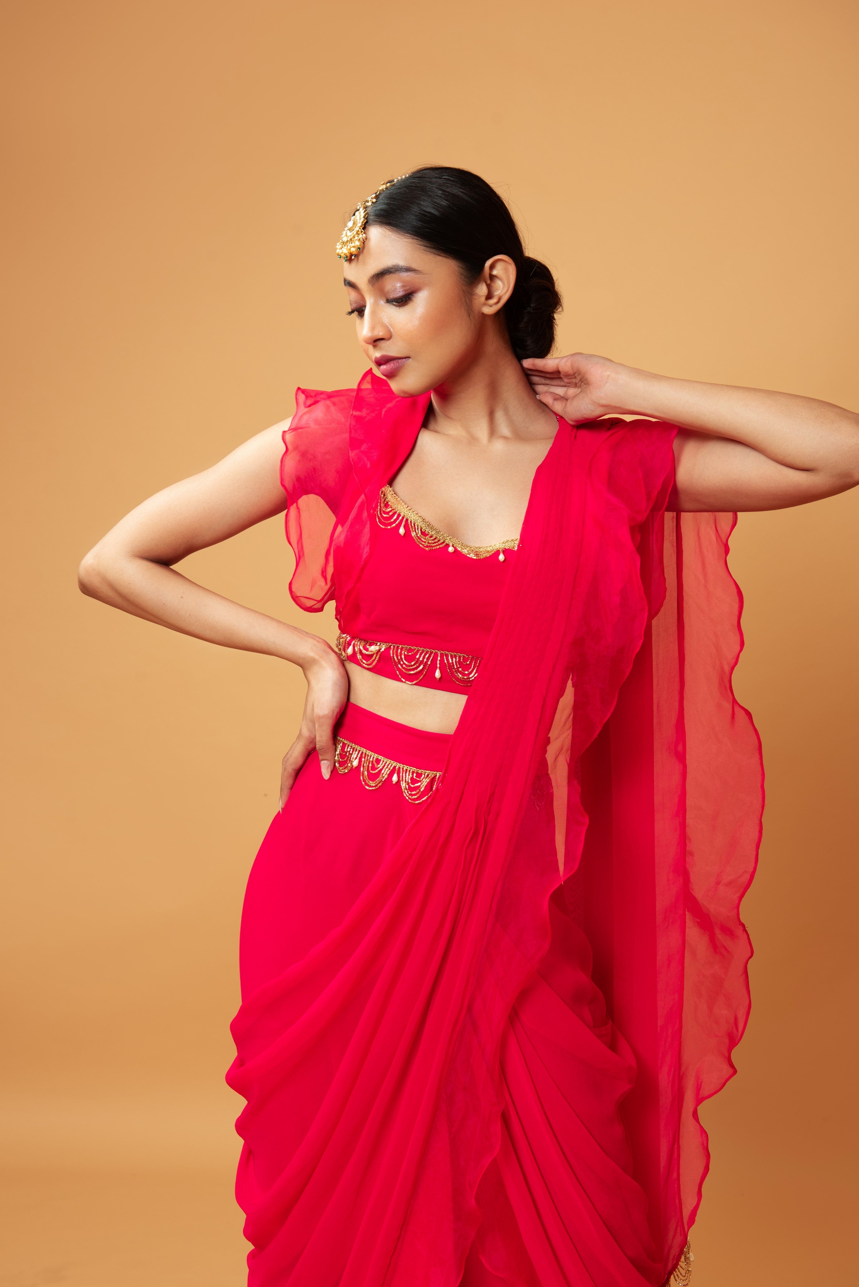 Fuschia pink ruffle saree with lace detailing on neckline and waist.