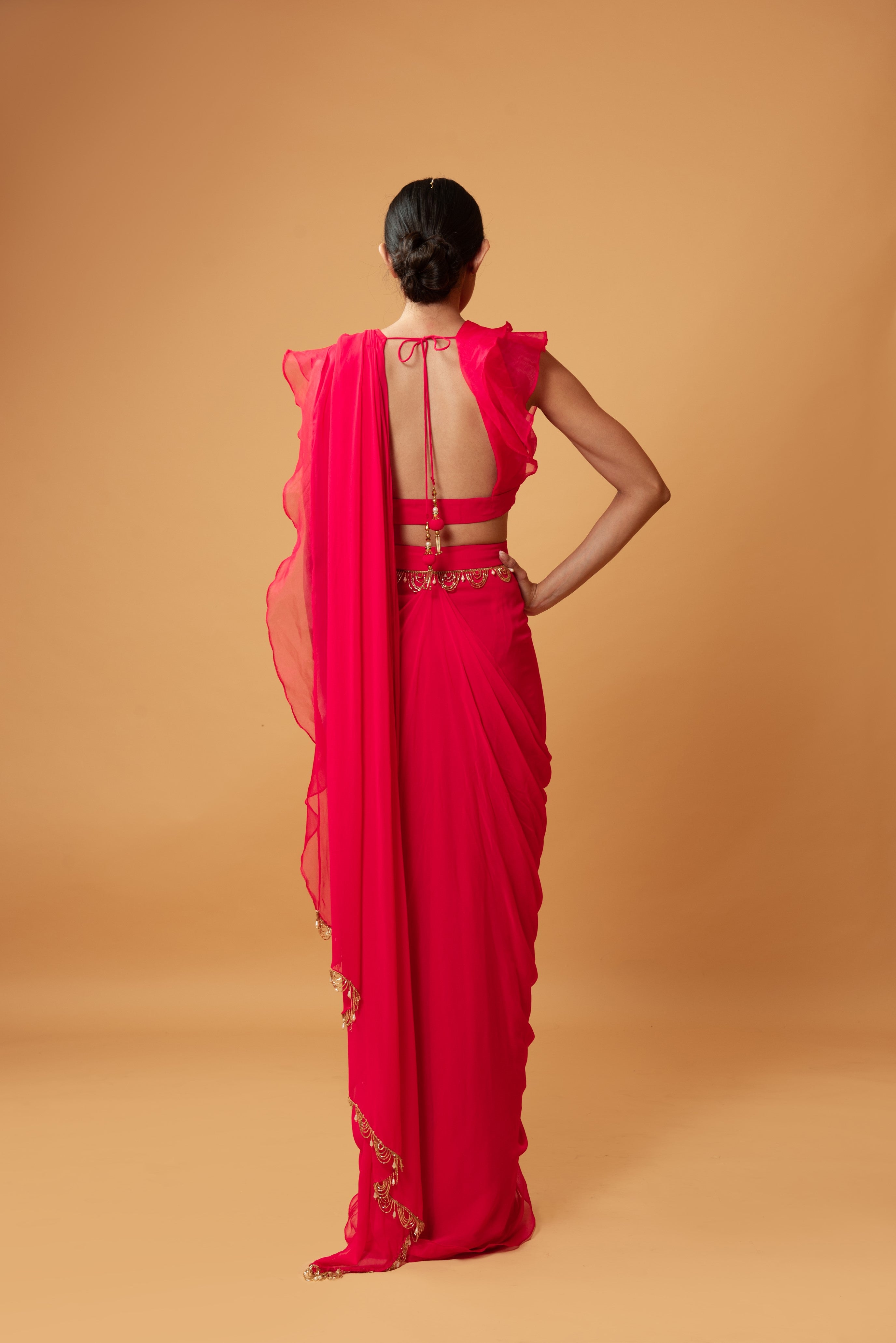 Fuschia pink ruffle saree with lace detailing on neckline and waist.