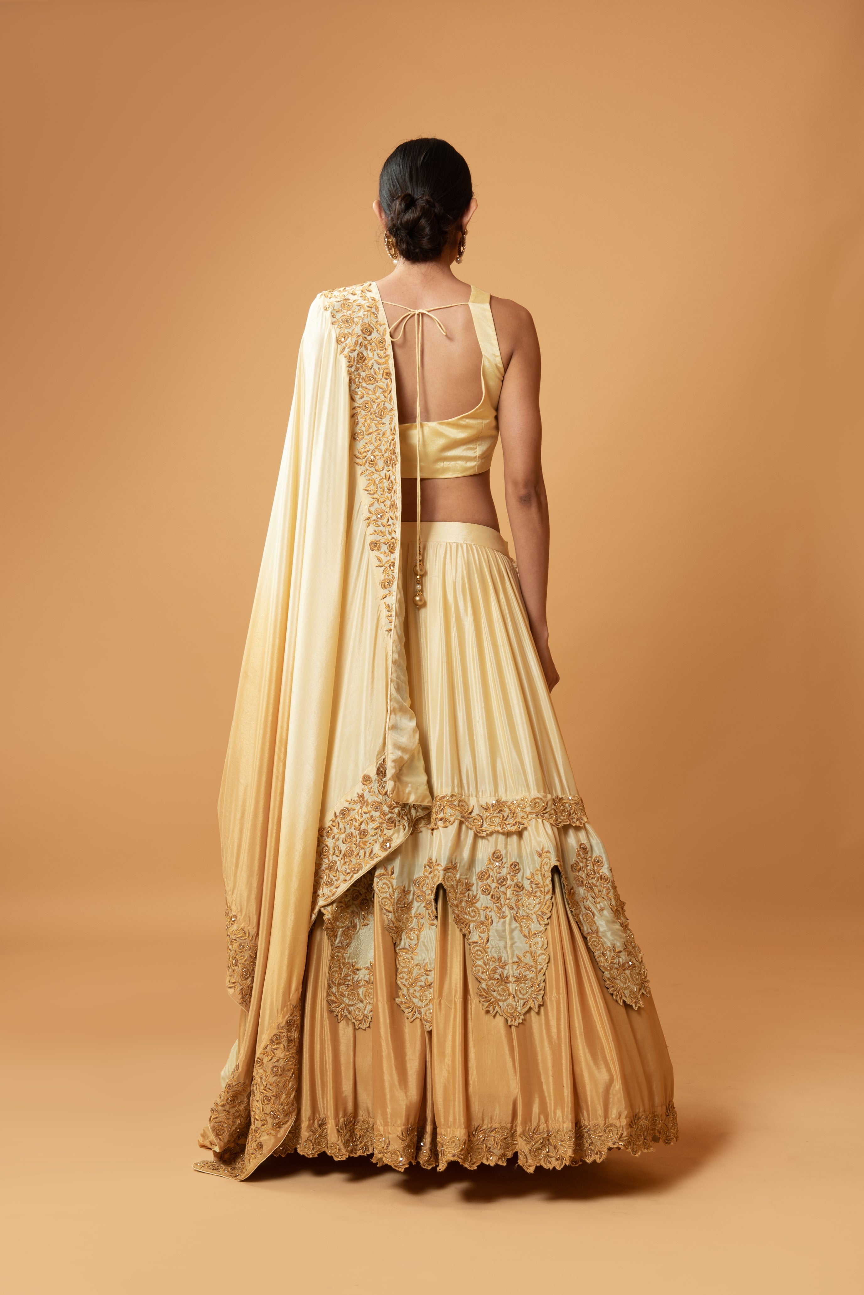 Golden ombre lehenga with floral embroidery and layered design.