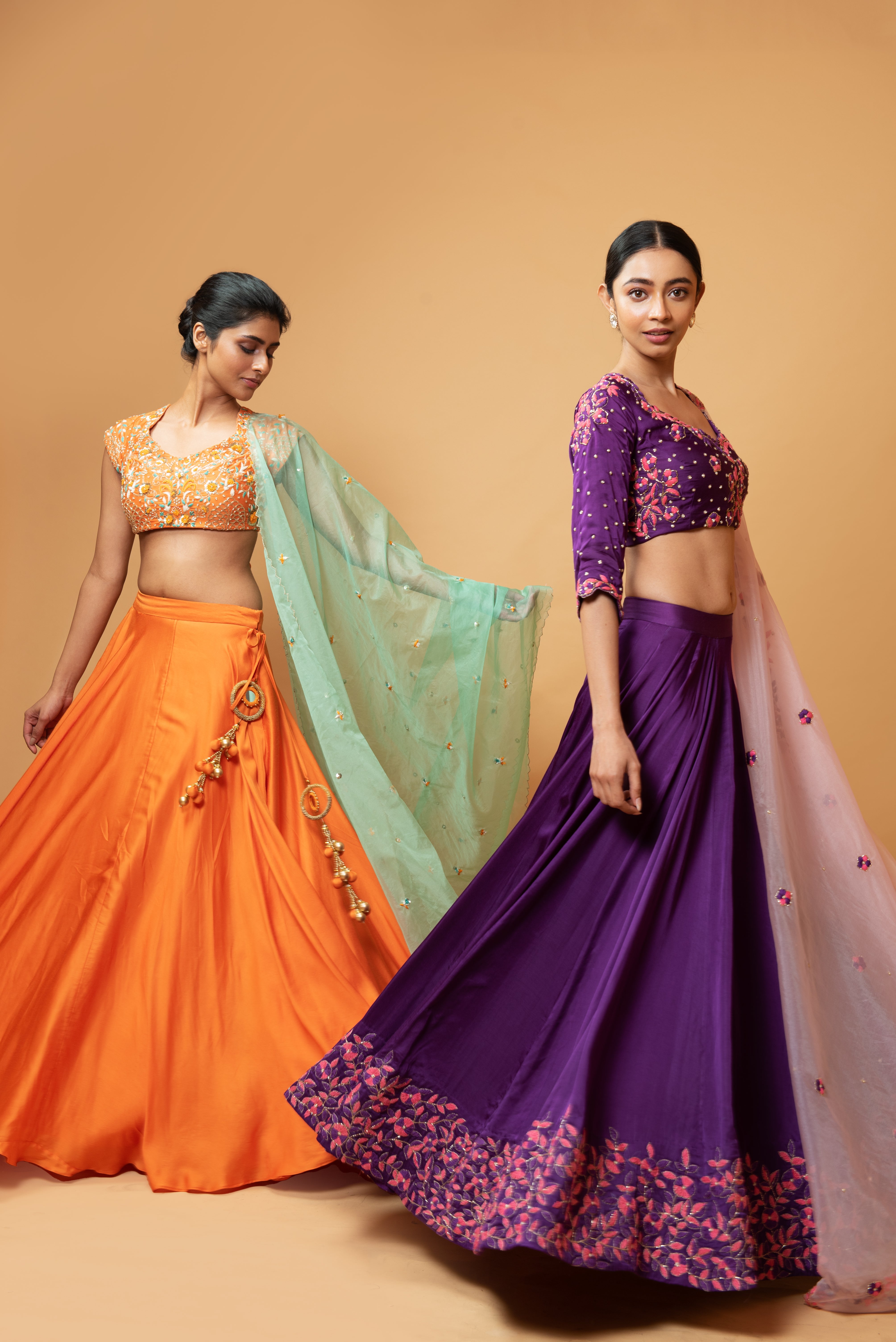 Violet lehenga with handwork paired with a contrasting pink dupatta.