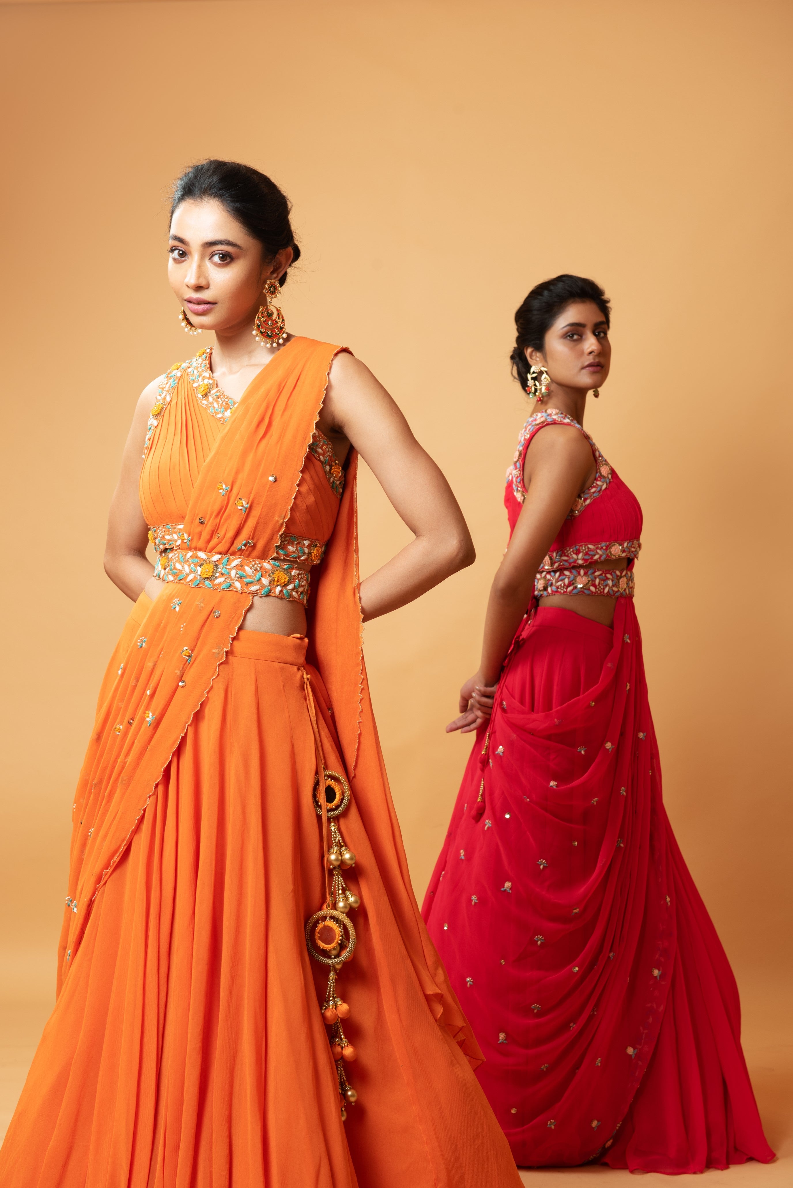 Bright orange draped lehenga with a matching embroidered belt.