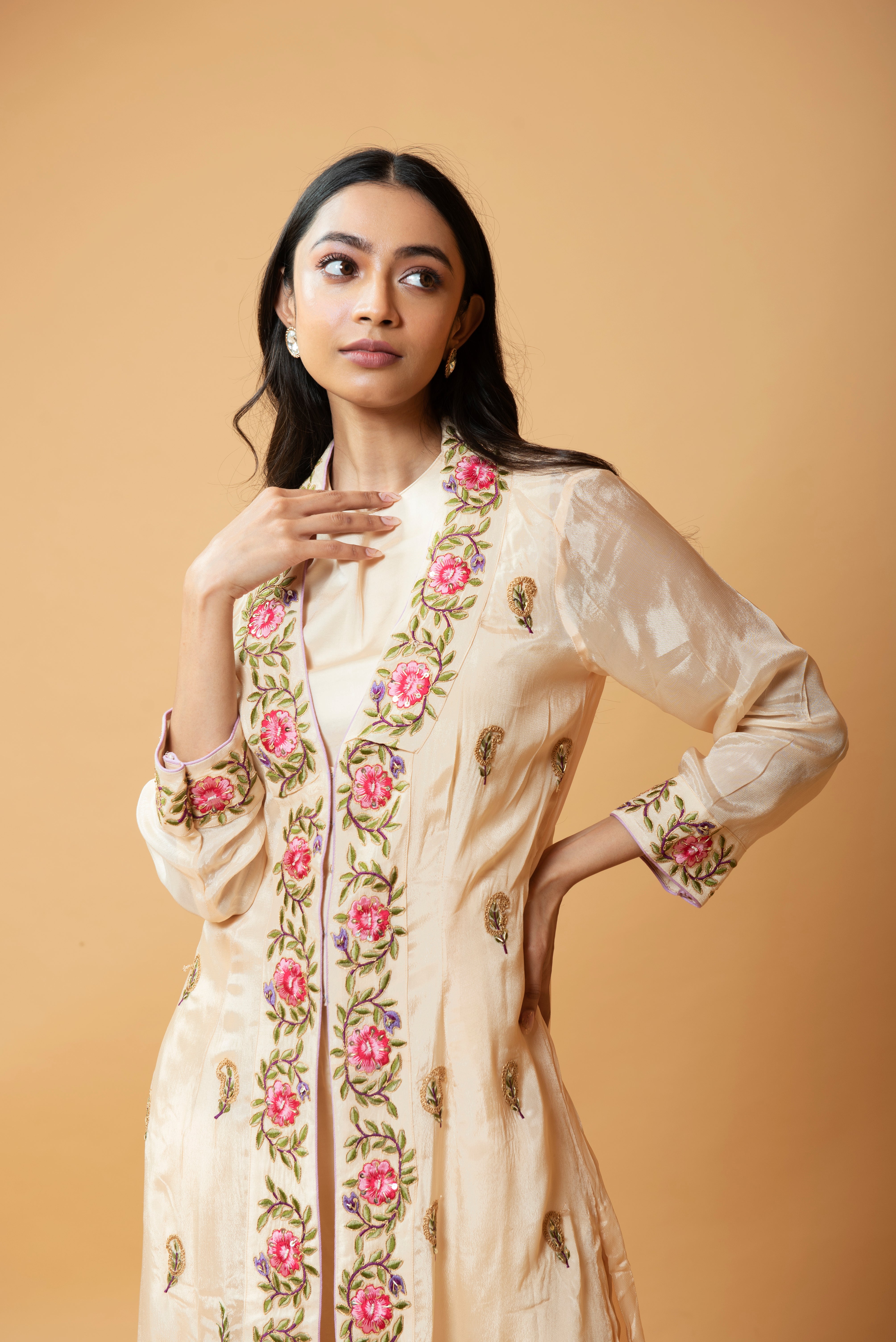 Champagne jumpsuit and jacket with floral embroidery and pockets.