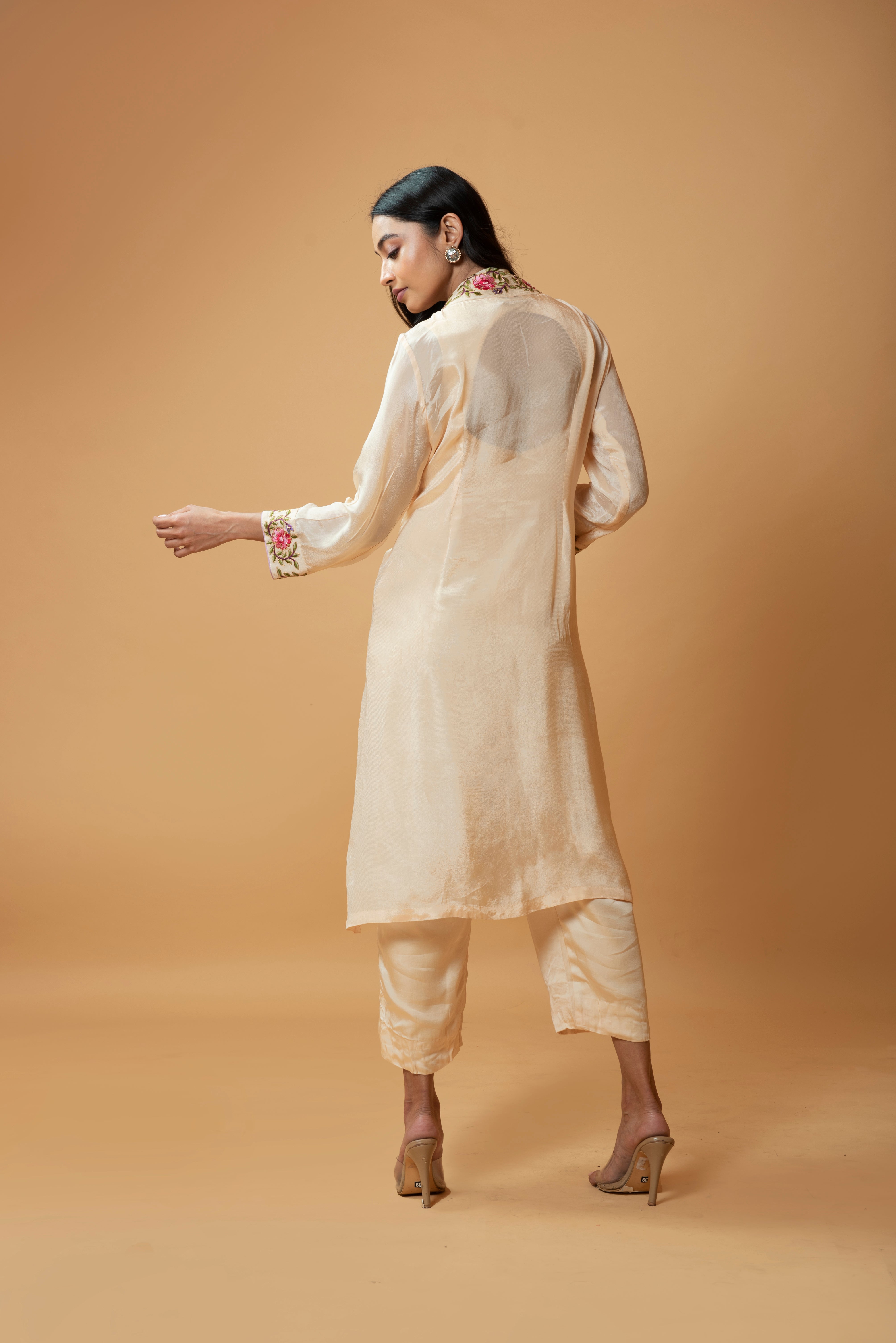 Champagne jumpsuit and jacket with floral embroidery and pockets.