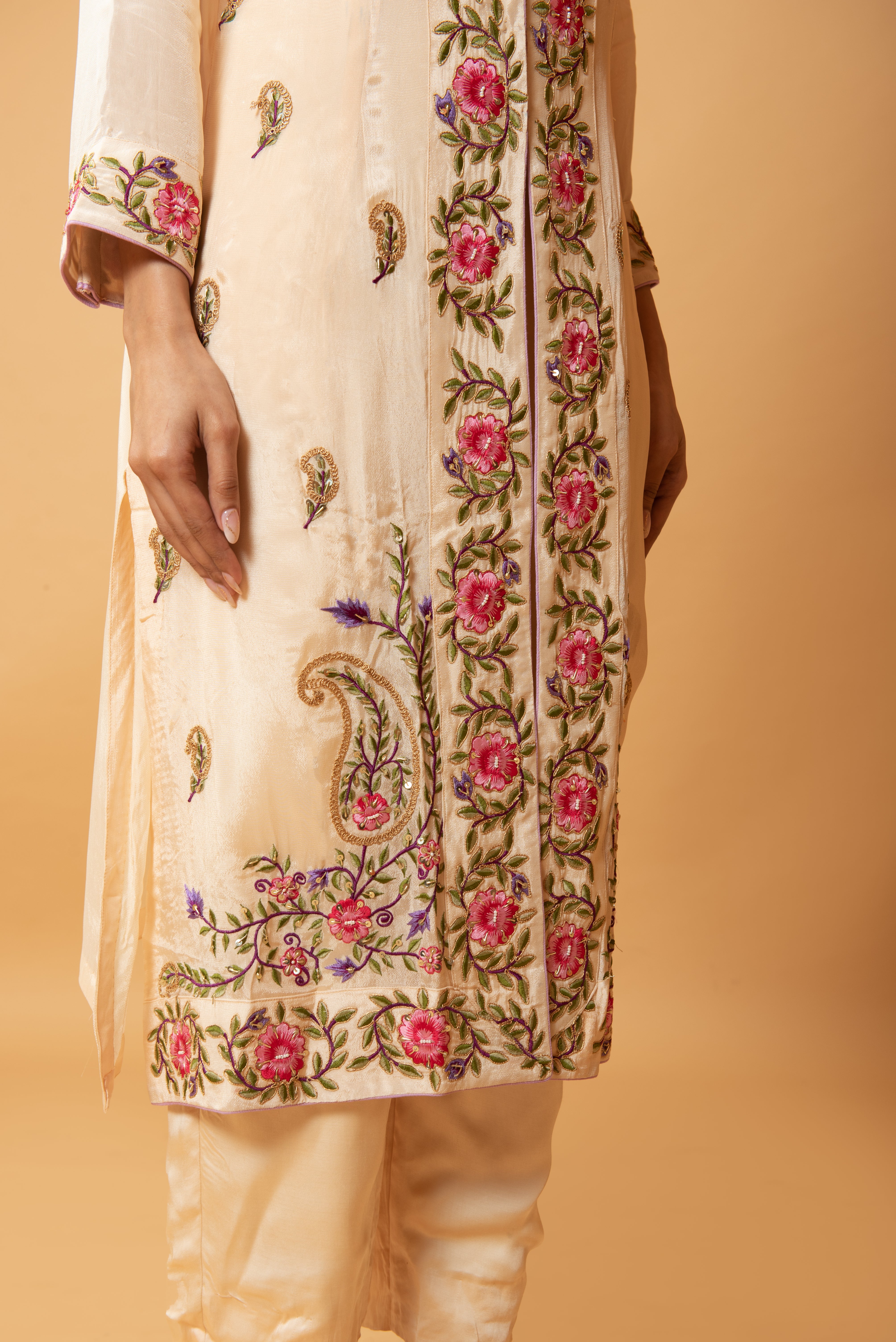 Champagne jumpsuit and jacket with floral embroidery and pockets.