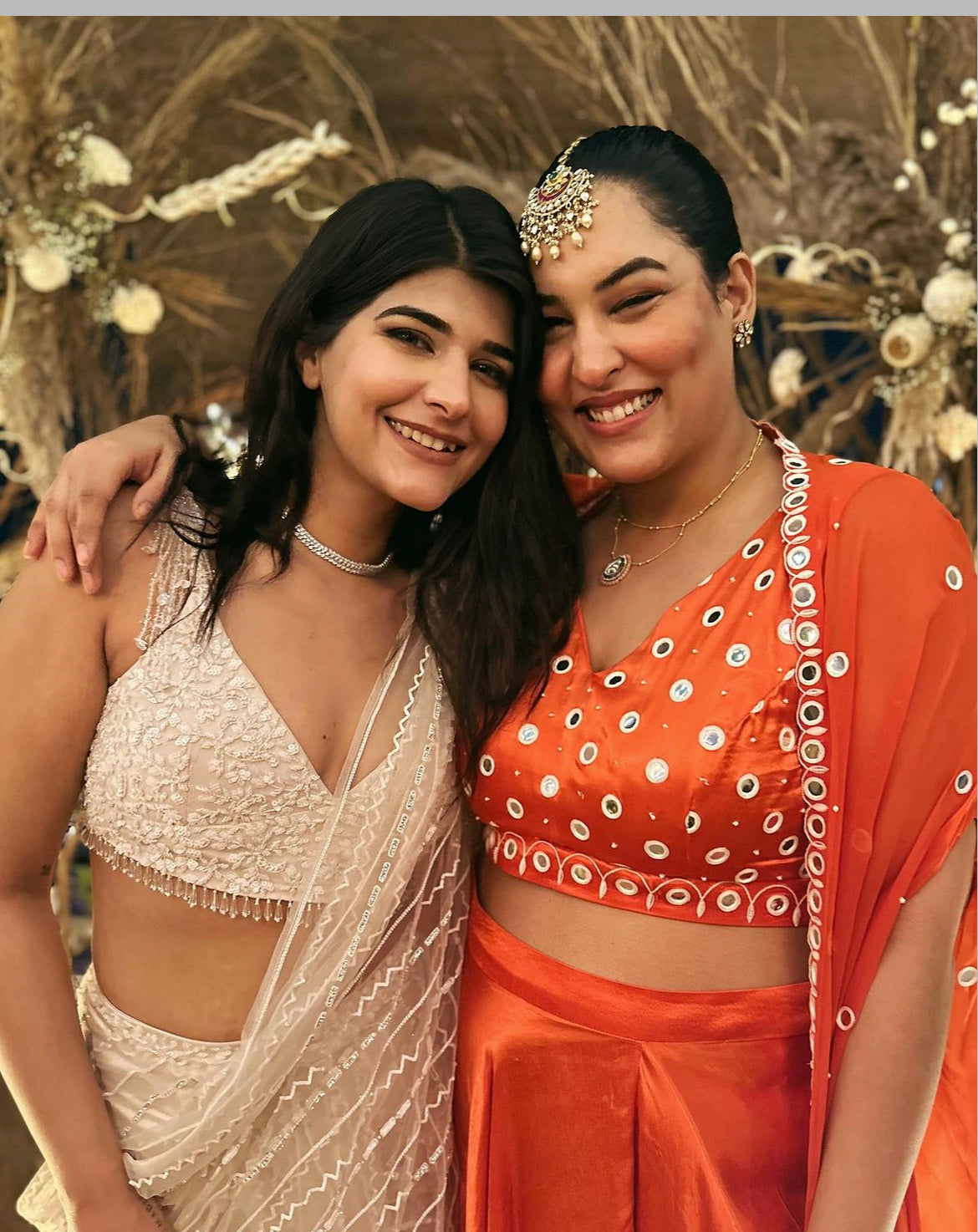 Sakshi Sindhwani wearing a tangerine orange dhoti set with mirror work blouse and cape.