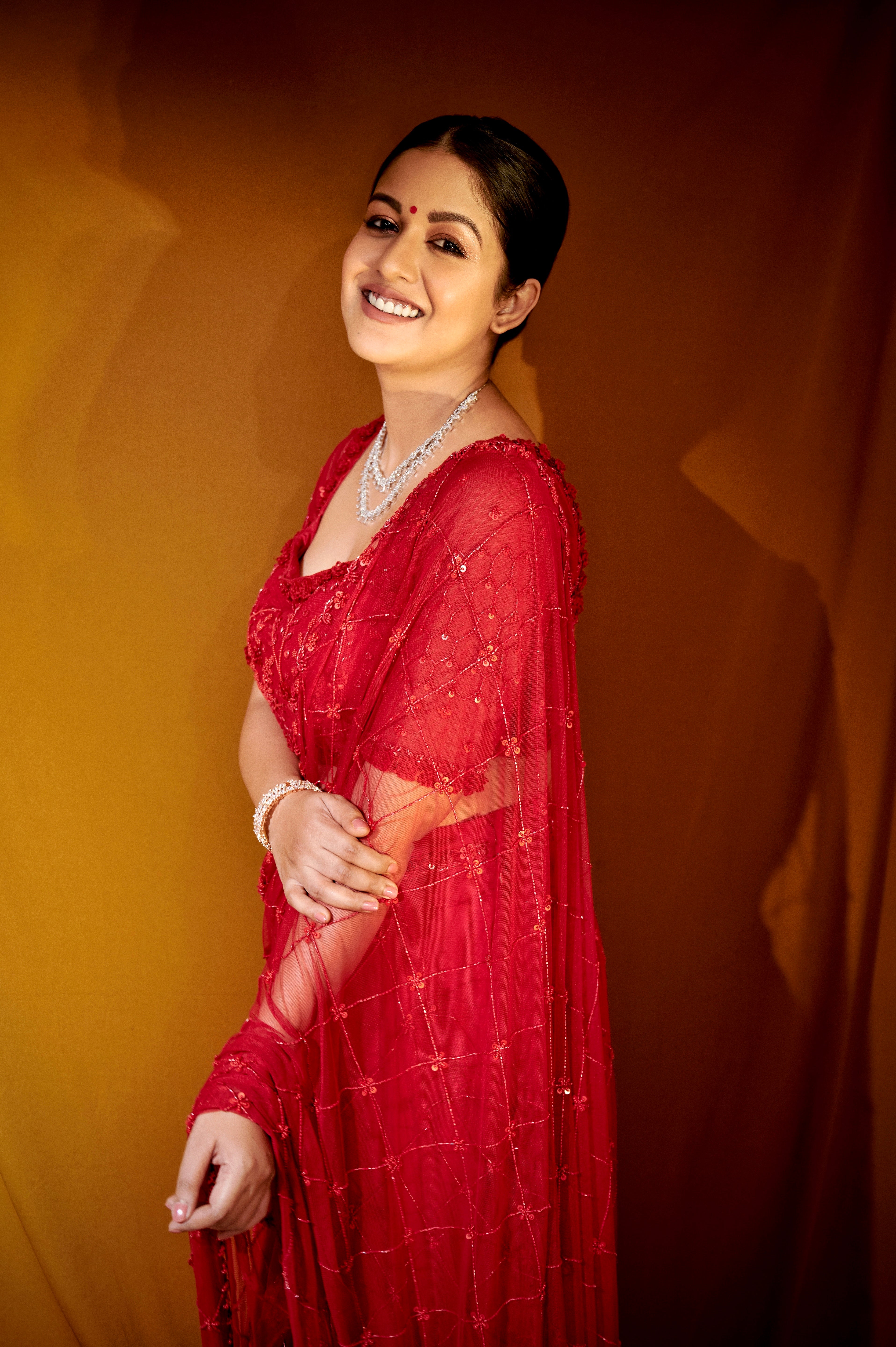 Ishita Dutta Sheth wearing a red soft net and georgette saree with intricate hand embroidery.