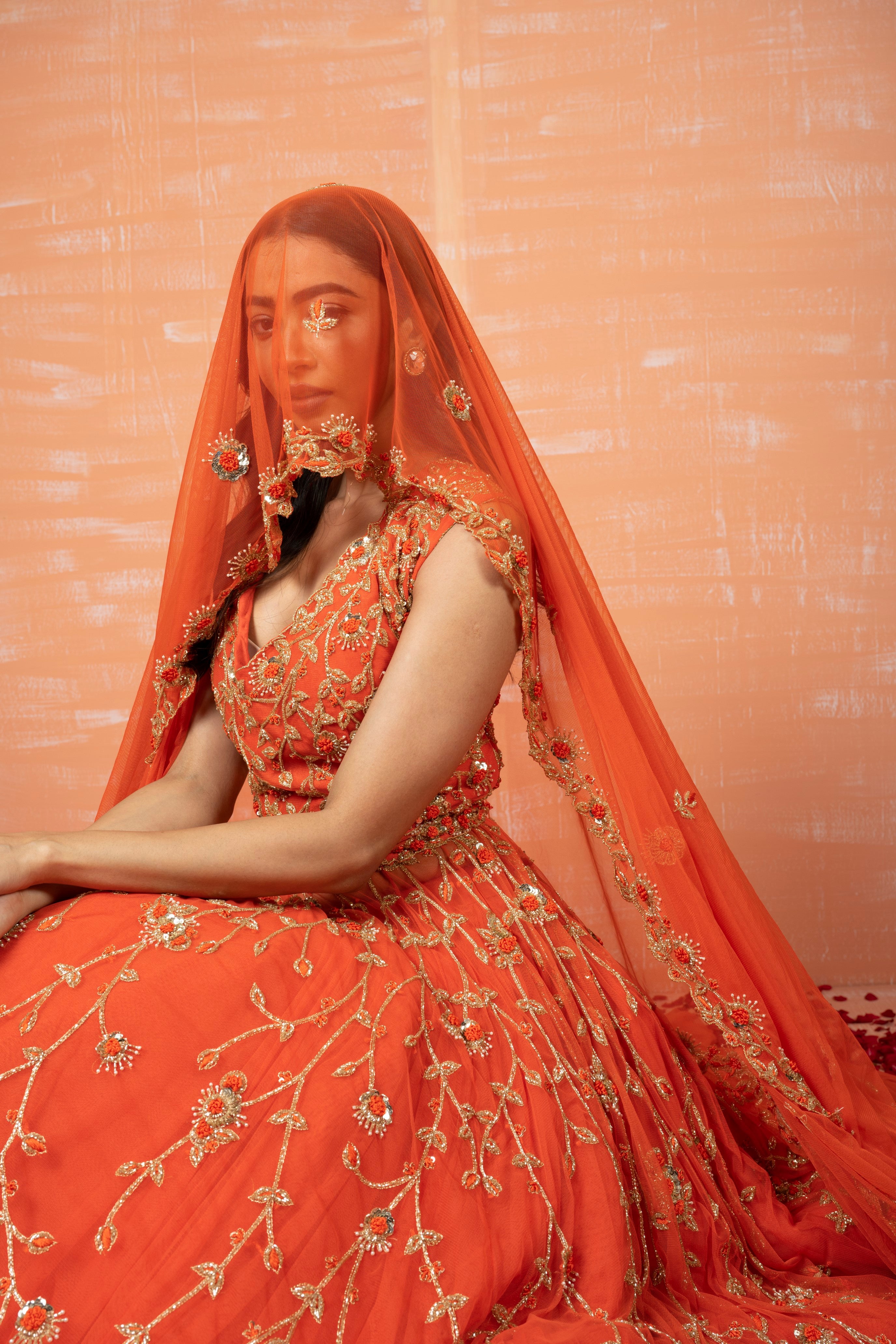 Orange soft net lehenga set with intricate zardosi embroidery, dupatta, and waist belt.