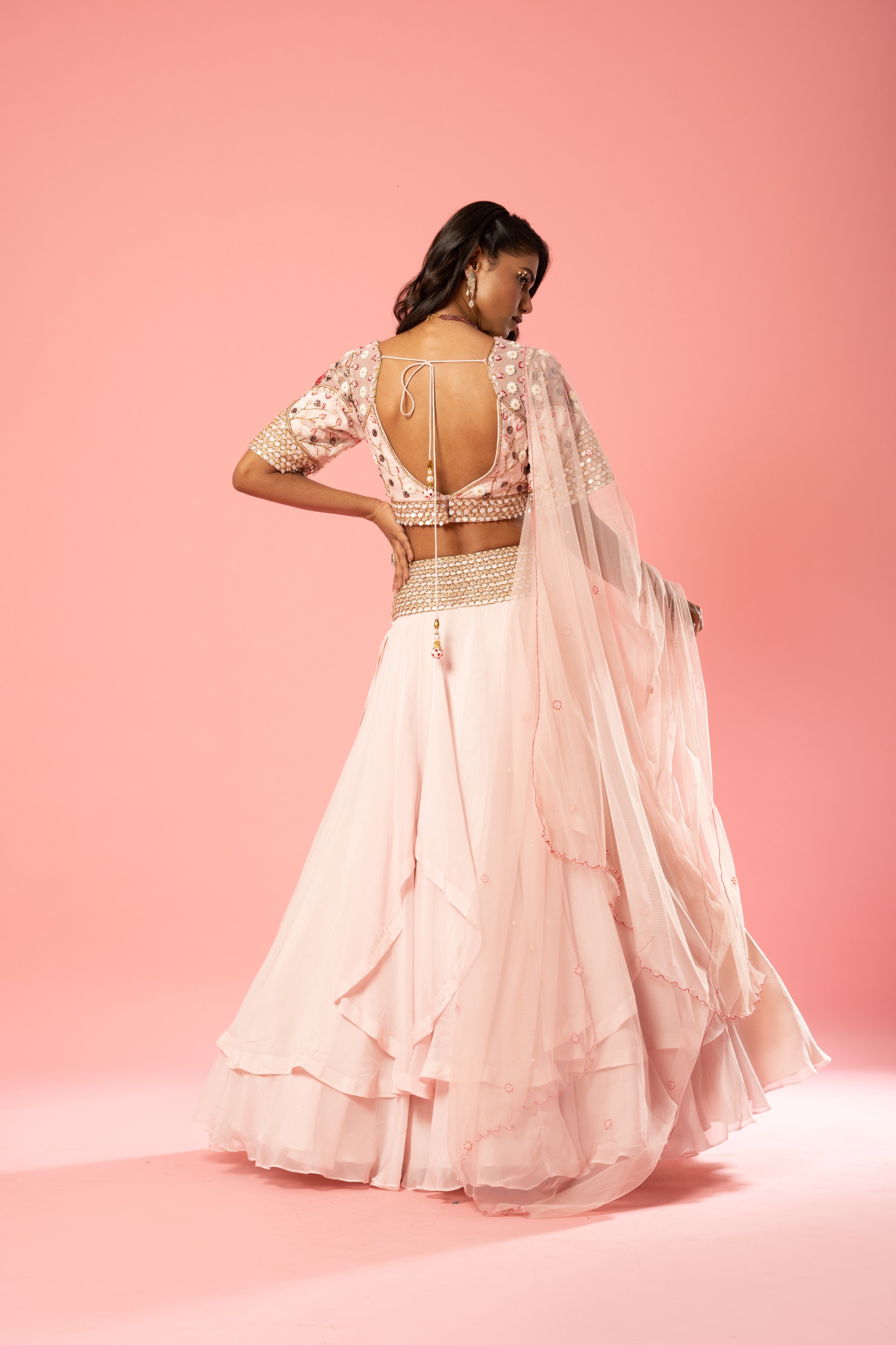 Baby pink organza lehenga with hand-embroidered blouse, belt, and net dupatta.