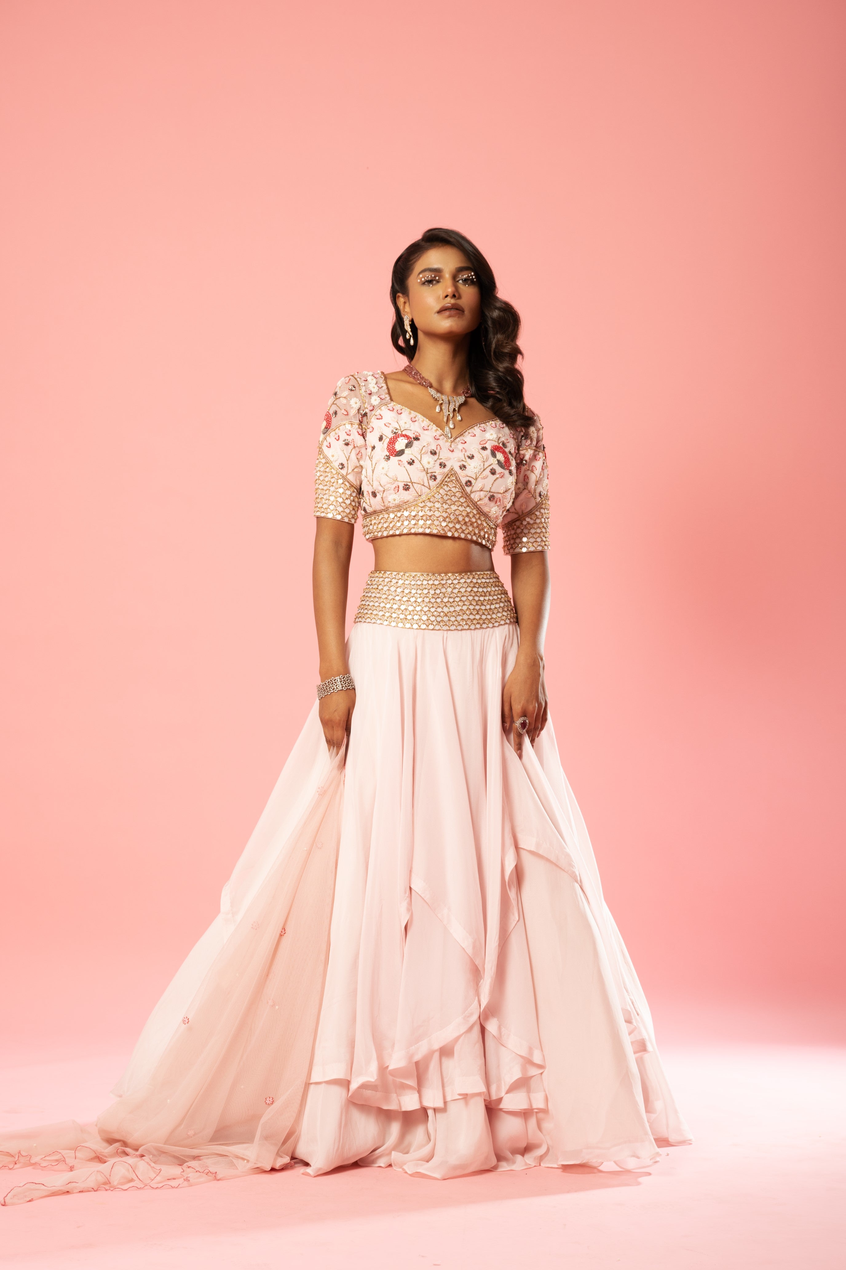 Baby pink organza lehenga with hand-embroidered blouse, belt, and net dupatta.