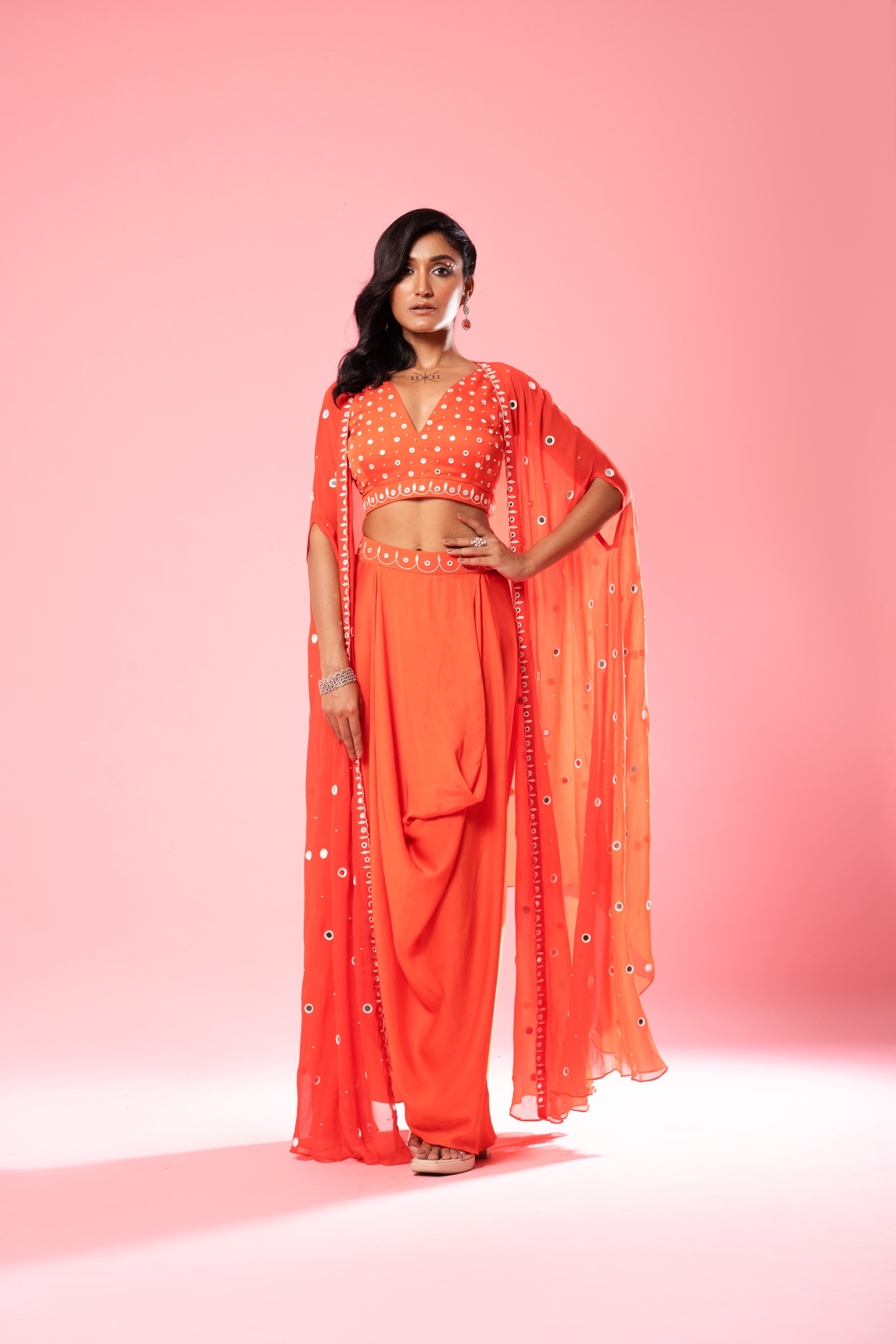 Tangerine orange dhoti set with mirror work blouse and georgette cape.