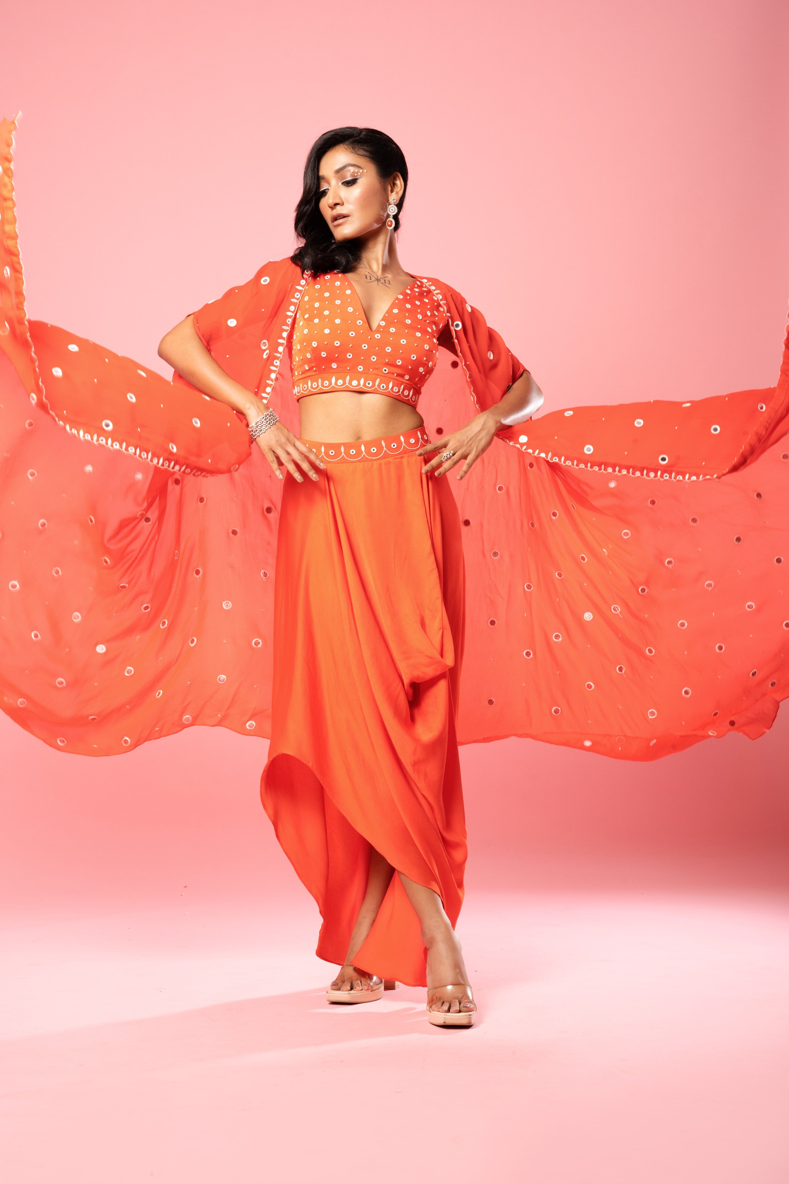 Tangerine orange dhoti set with mirror work blouse and georgette cape.