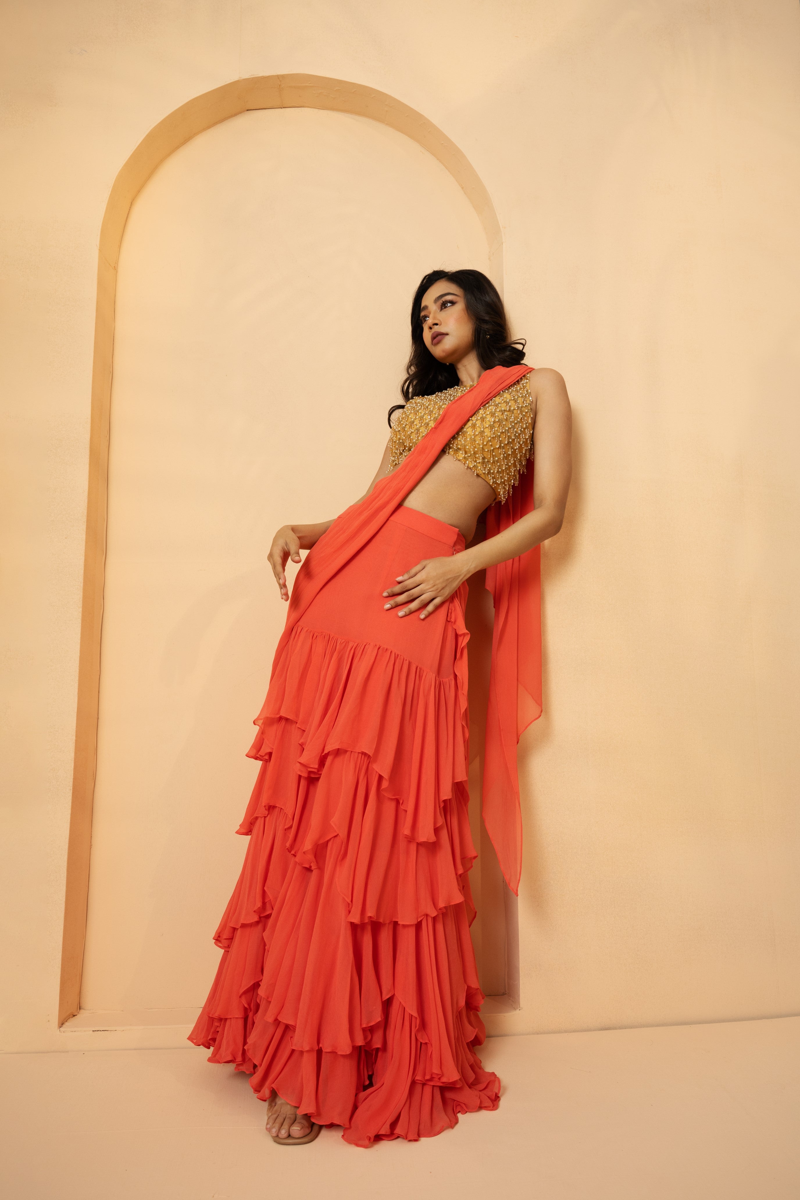 Peach pre-stitched ruffle saree with georgette and net, detailed with cutdana and beadwork.