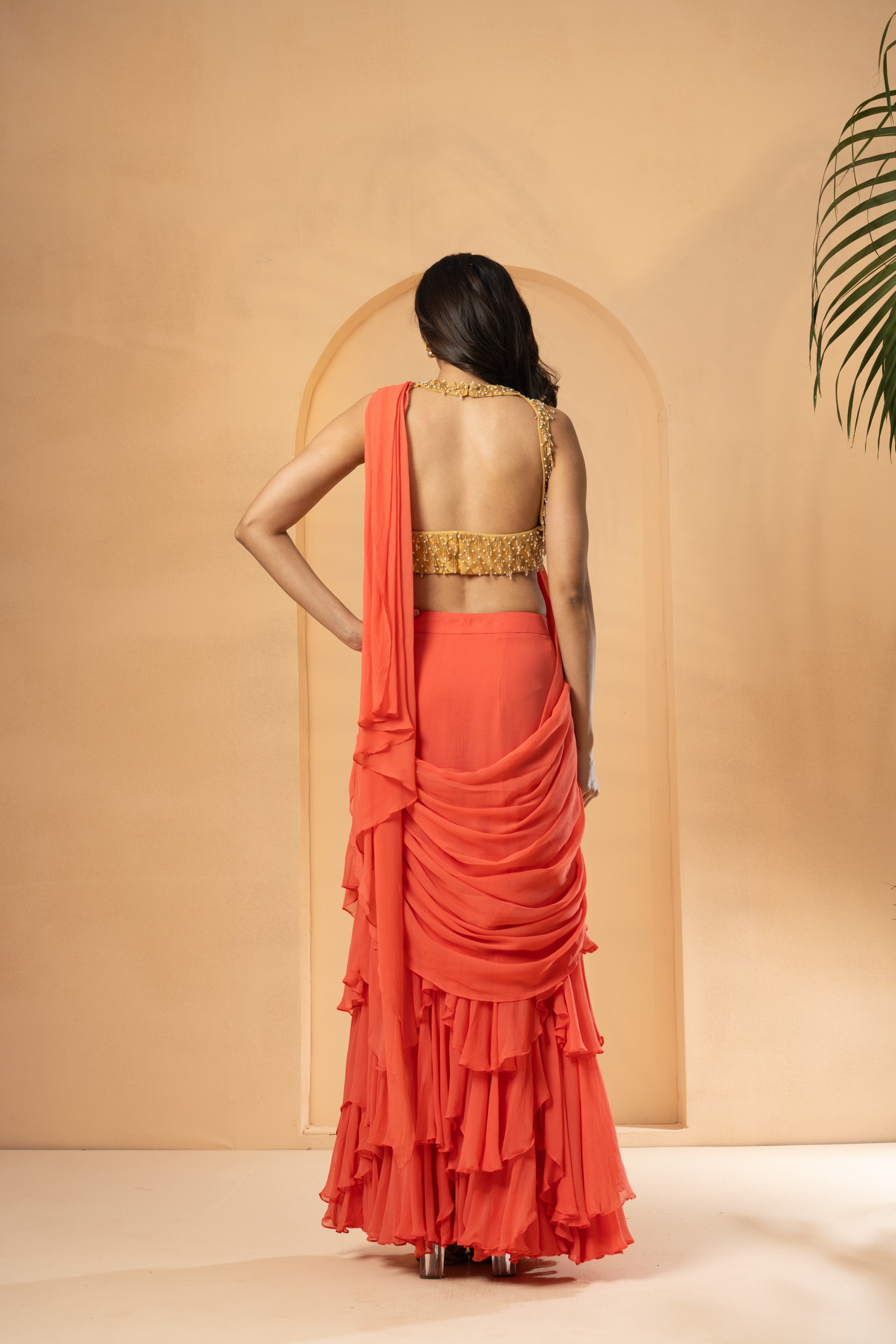 Peach pre-stitched ruffle saree with georgette and net, detailed with cutdana and beadwork.