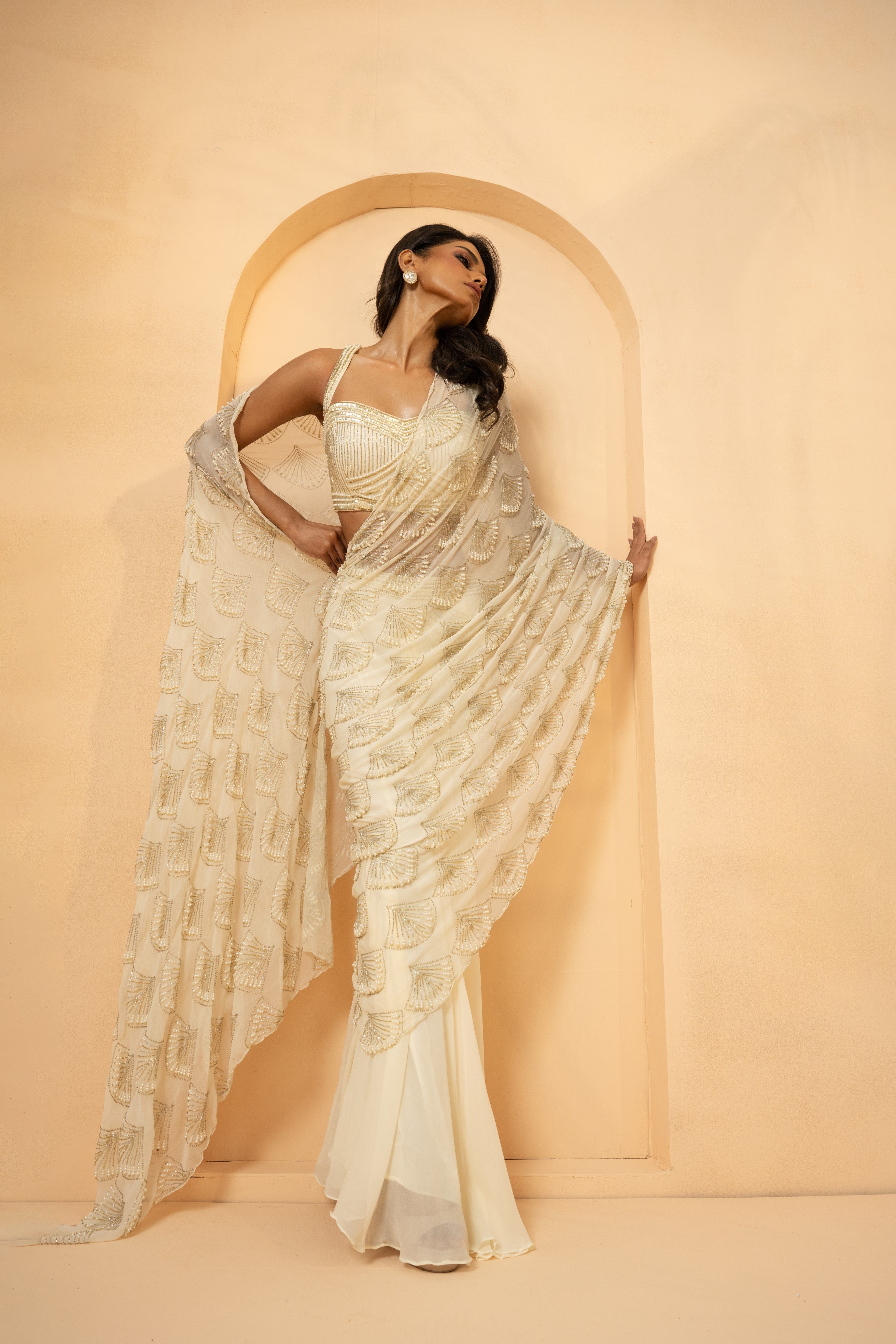 Ivory pre-stitched drape saree with intricate self-on-self embroidery.