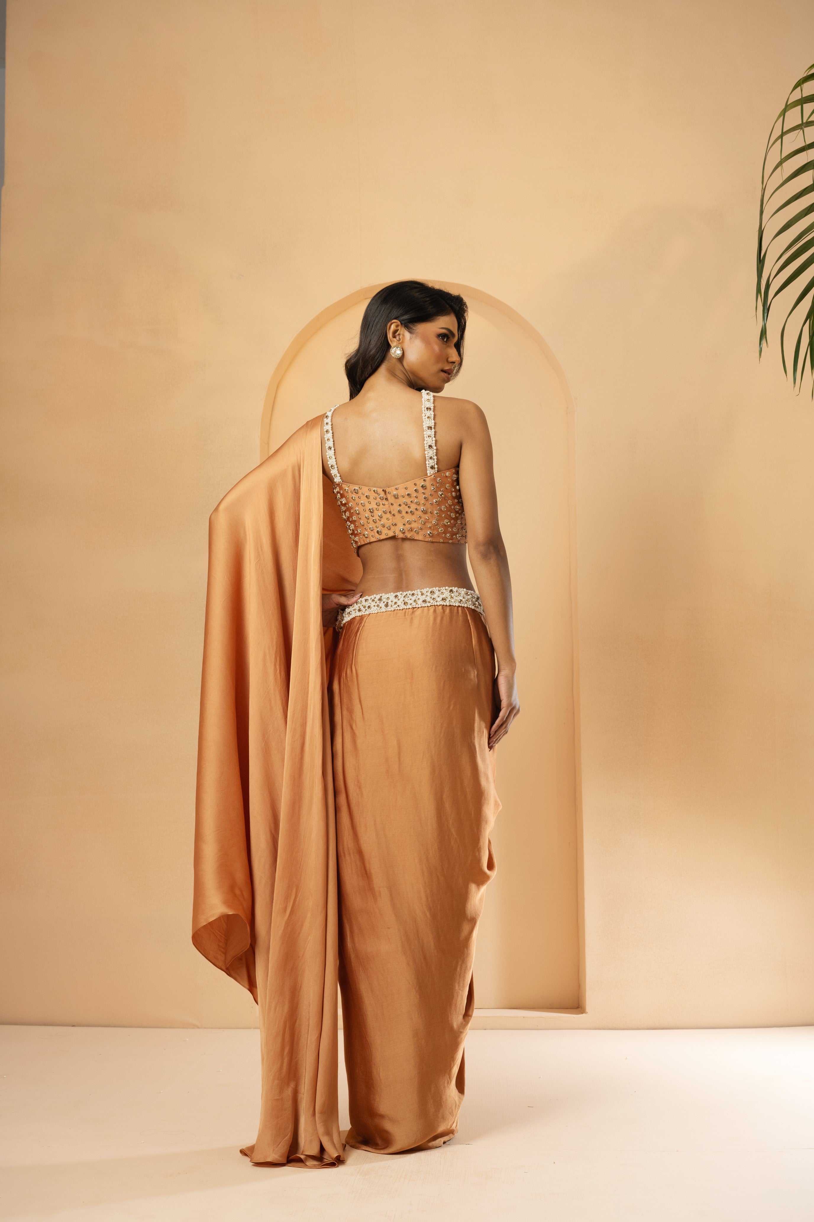 Golden pre-stitched corset saree with intricate embroidery.