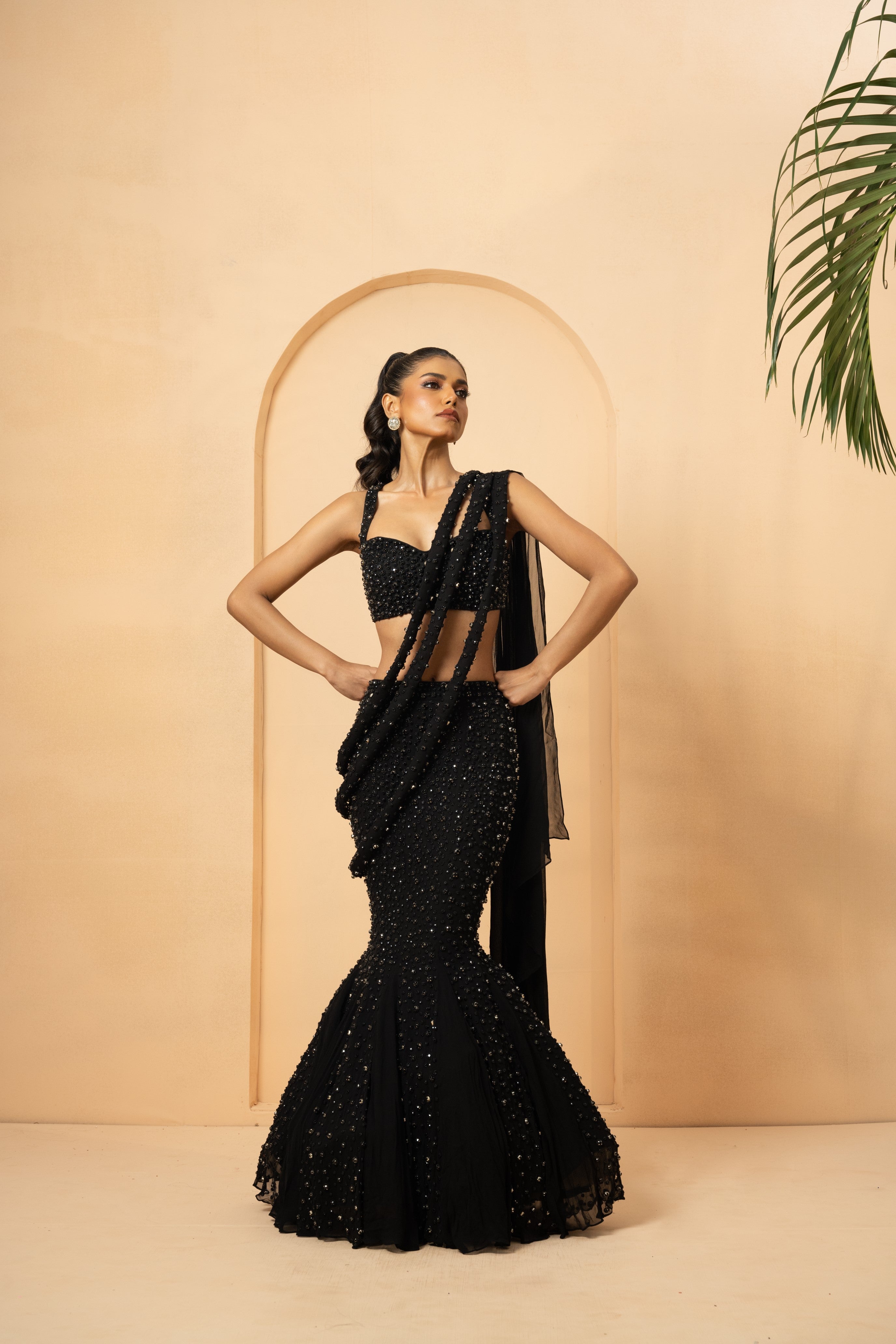 Black fishtail lehenga with twisted drape dupatta and crystal-stone embroidery.