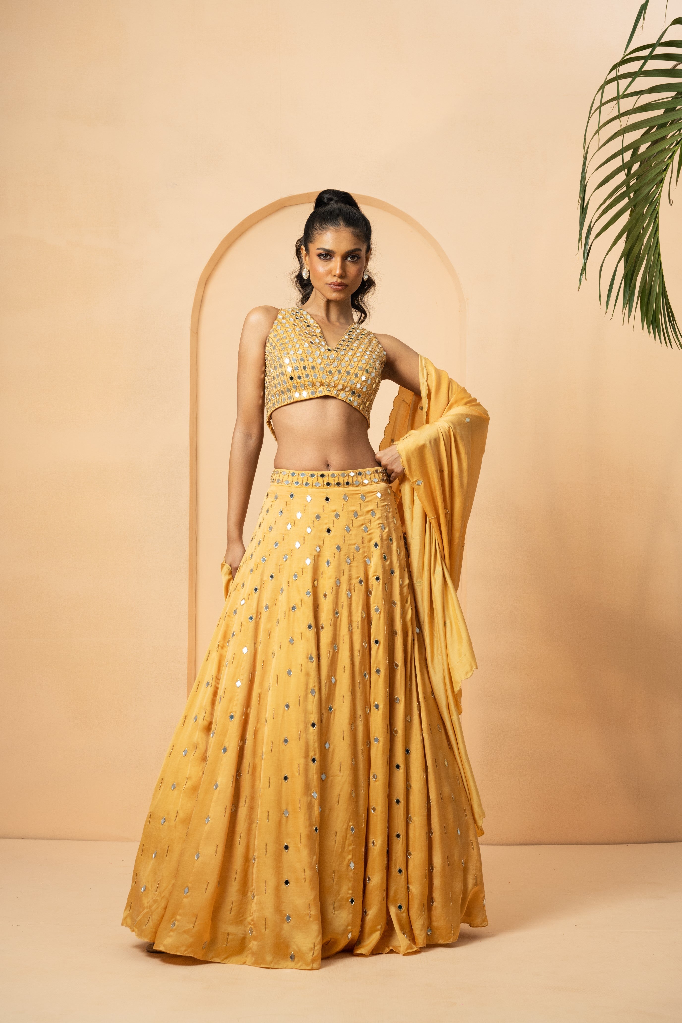 Golden lehenga with mirror and pearl embellishments on blouse and dupatta.