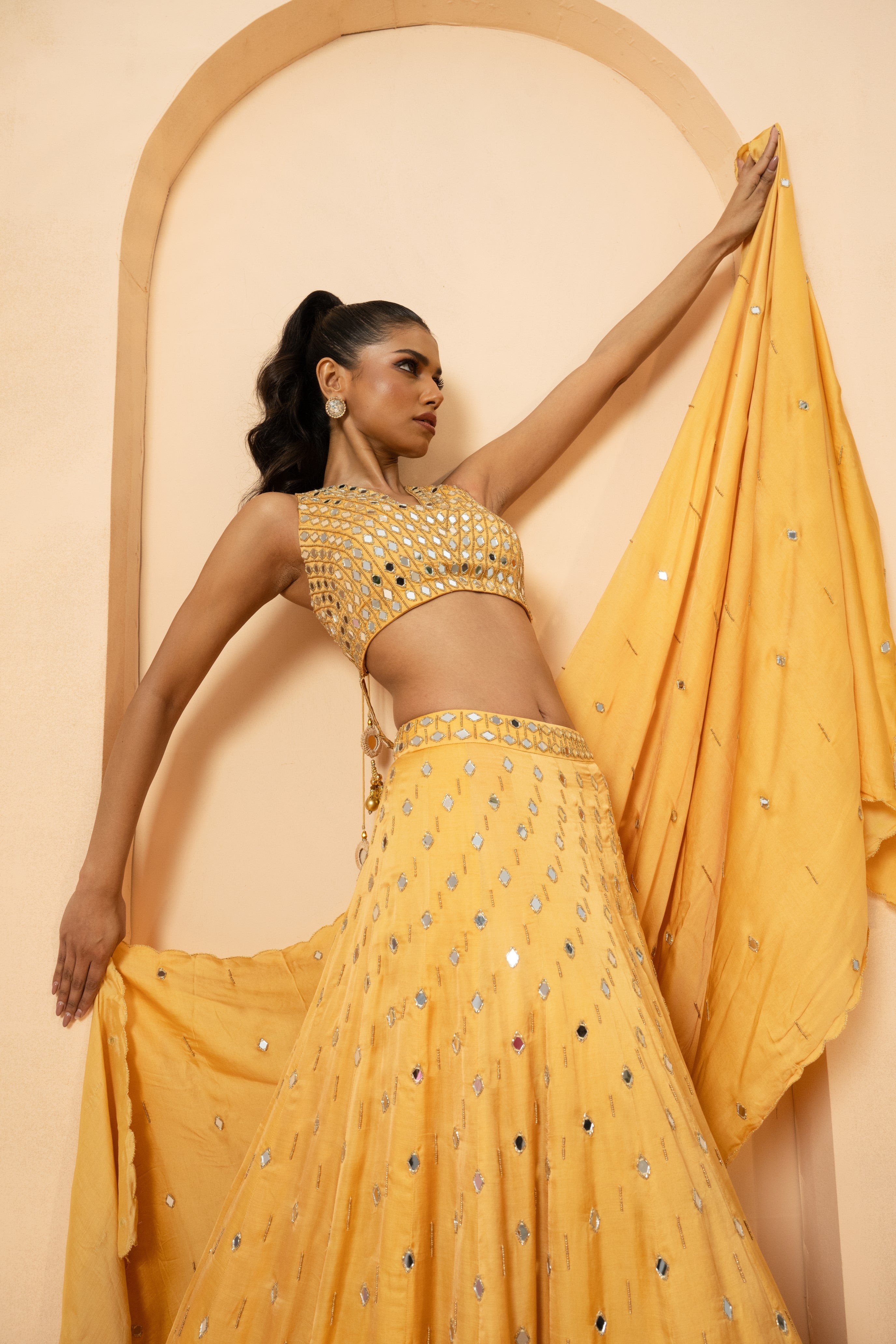 Golden lehenga with mirror and pearl embellishments on blouse and dupatta.