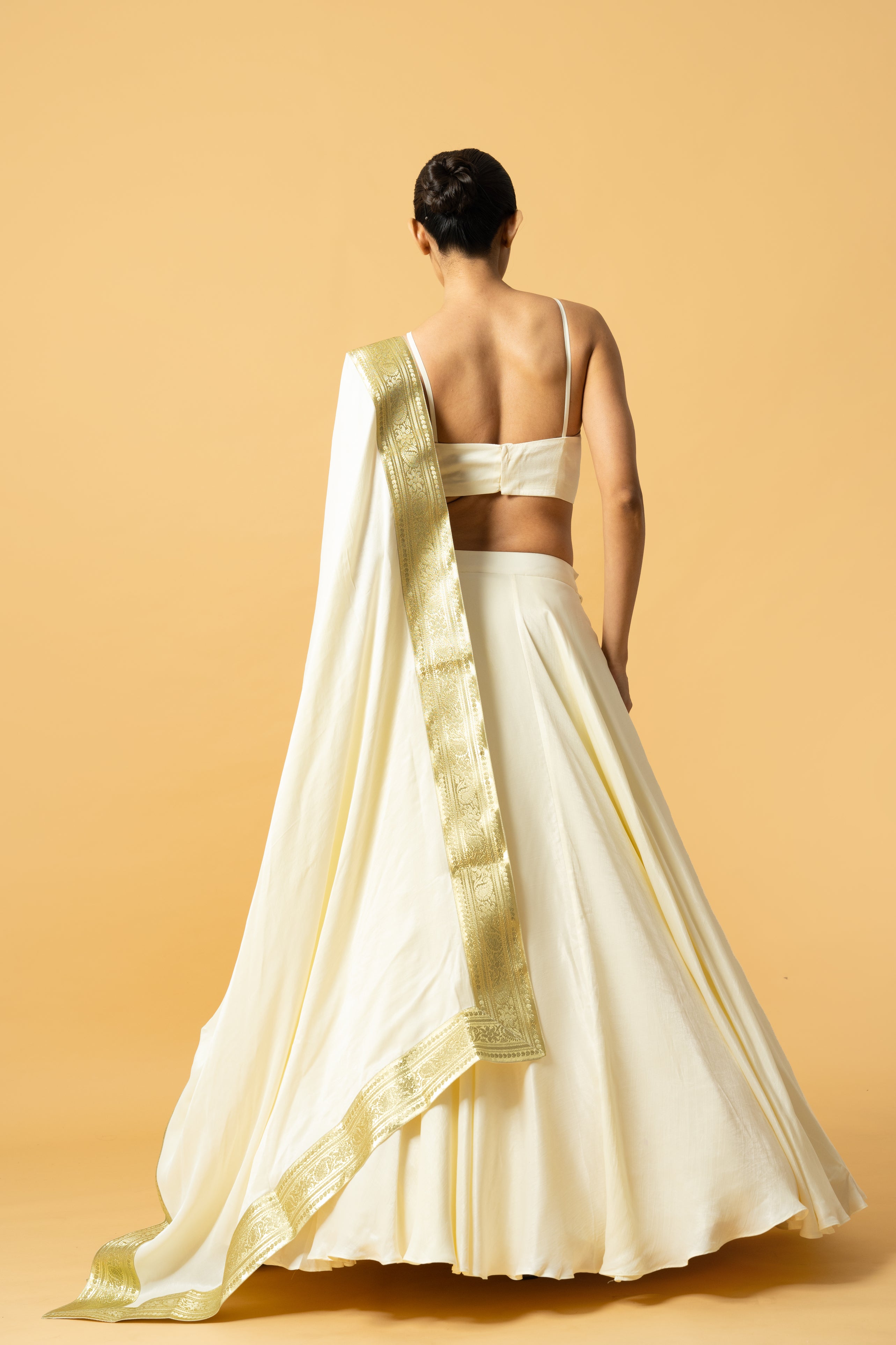Ivory modal satin lehenga with a golden lace dupatta and latkan details.